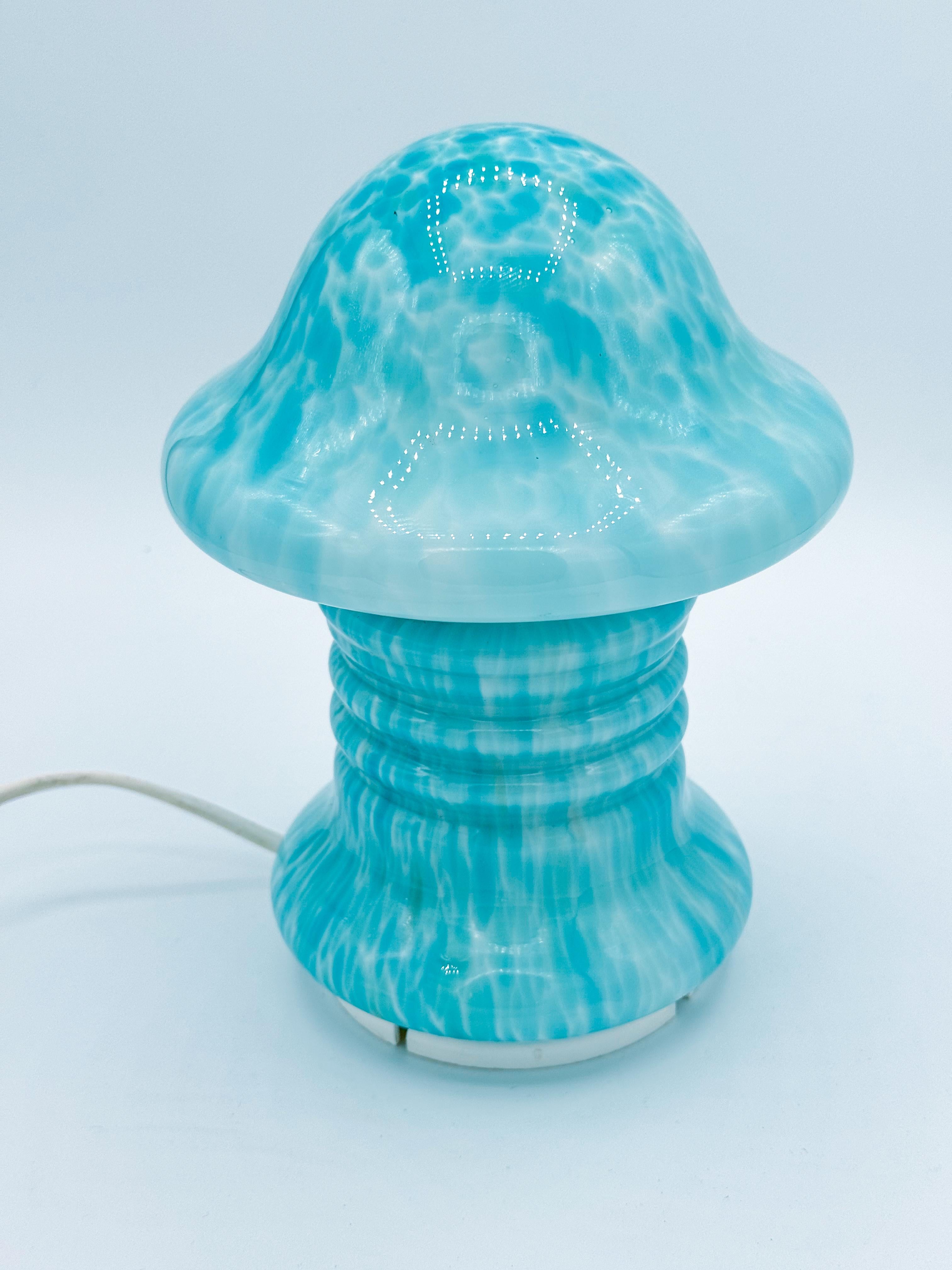 This rare mid-century mini mushroom table lamp by renowned Swedish designer Monica Backström is a true collector's piece. 
Crafted from delicate light blue glass, this lamp captures the essence of Scandinavian design with its sleek, organic mushroom