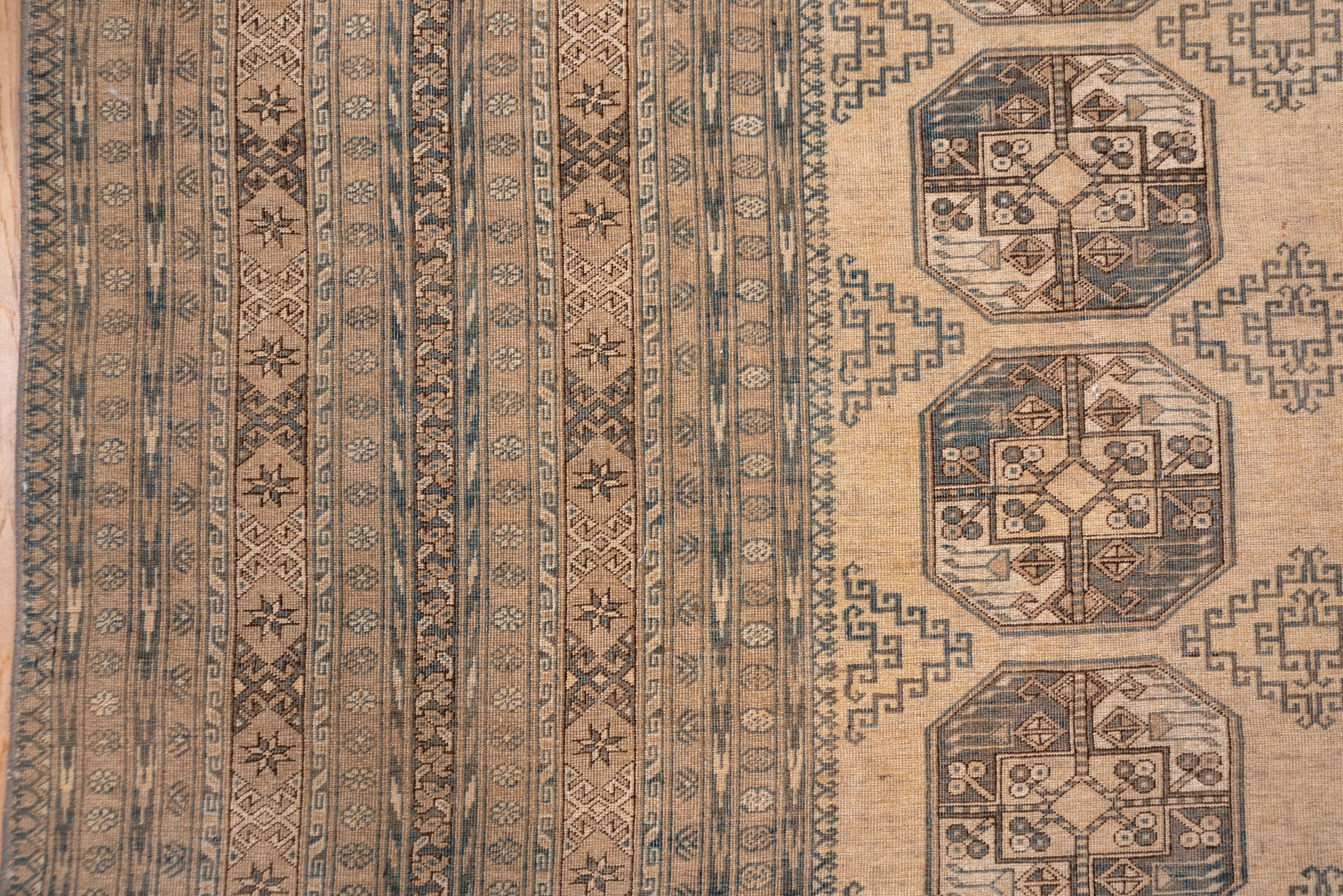 Three columns of quartered octagonal Ersari Turkmen guls with smaller lozenge-form hooked minor guls are evenly placed on the tan field while a highly complex frame composed of over a dozen patterned stripes frames the composition. Cool double
