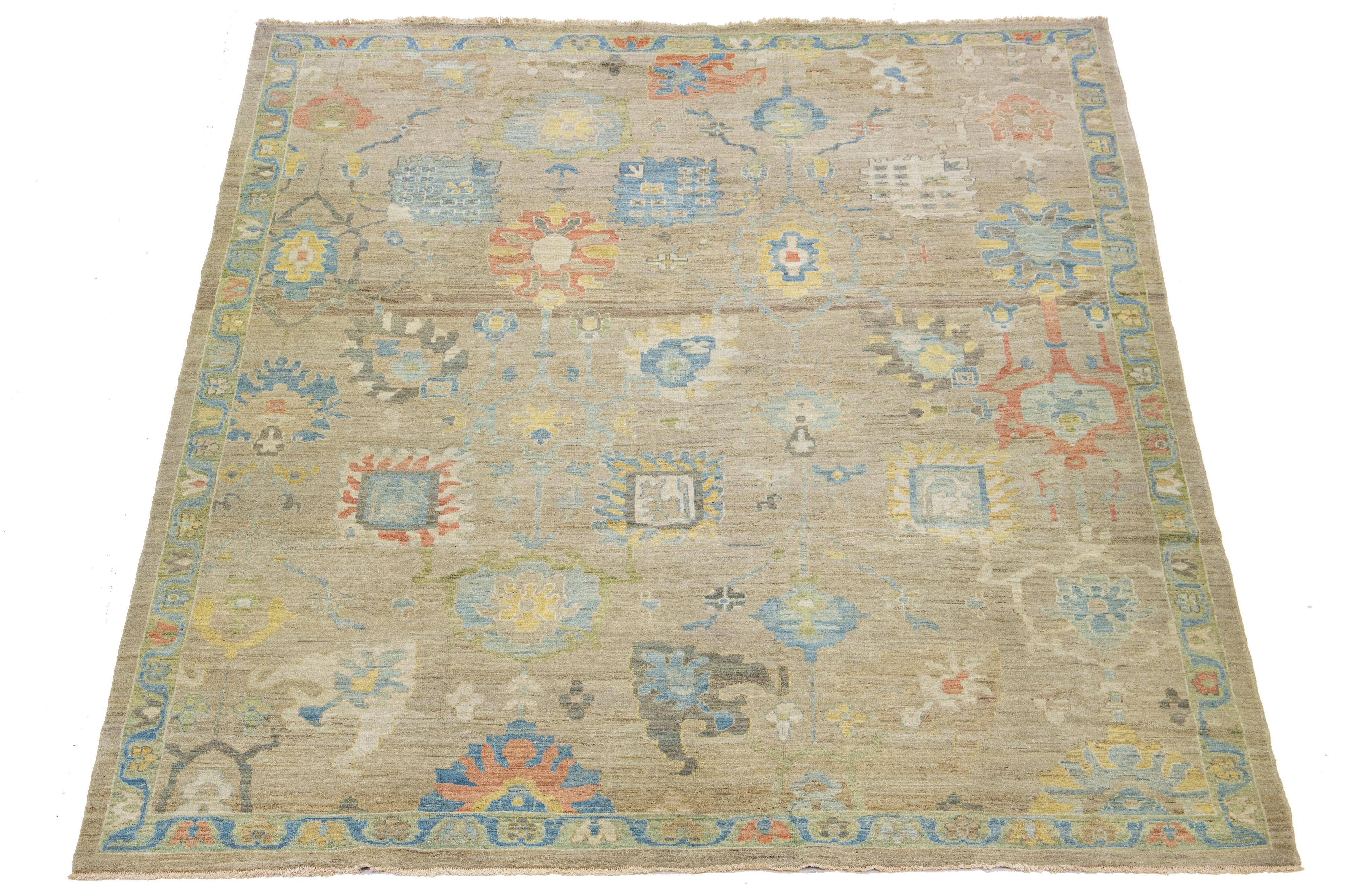 This Sultanabad classic style has been meticulously transformed into a contemporary masterpiece. Crafted with great care, this magnificent wool rug has a light brown field. It has an all-over floral motif. To enhance its elegance, it incorporates a