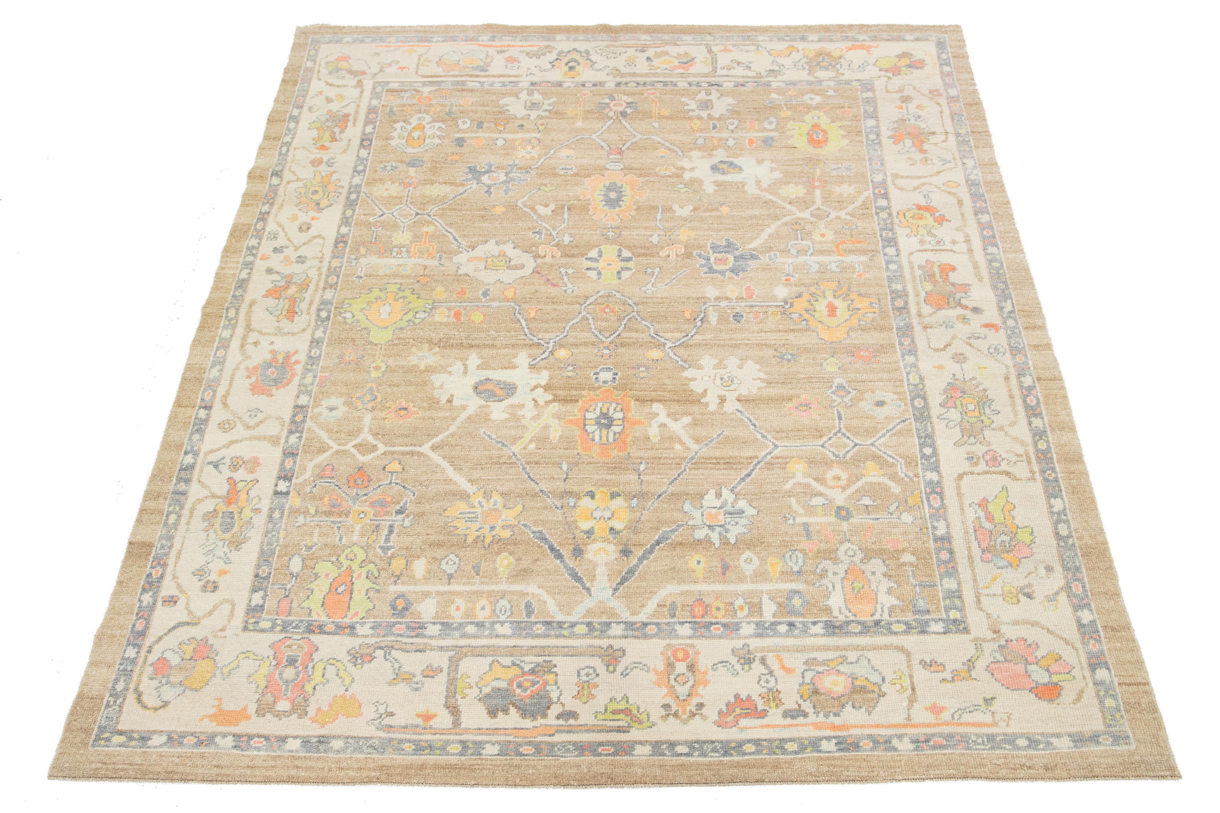 This hand-knotted wool rug is modern Turkish and features a light brown field with a captivating multicolor floral pattern.

This rug measures 8'7