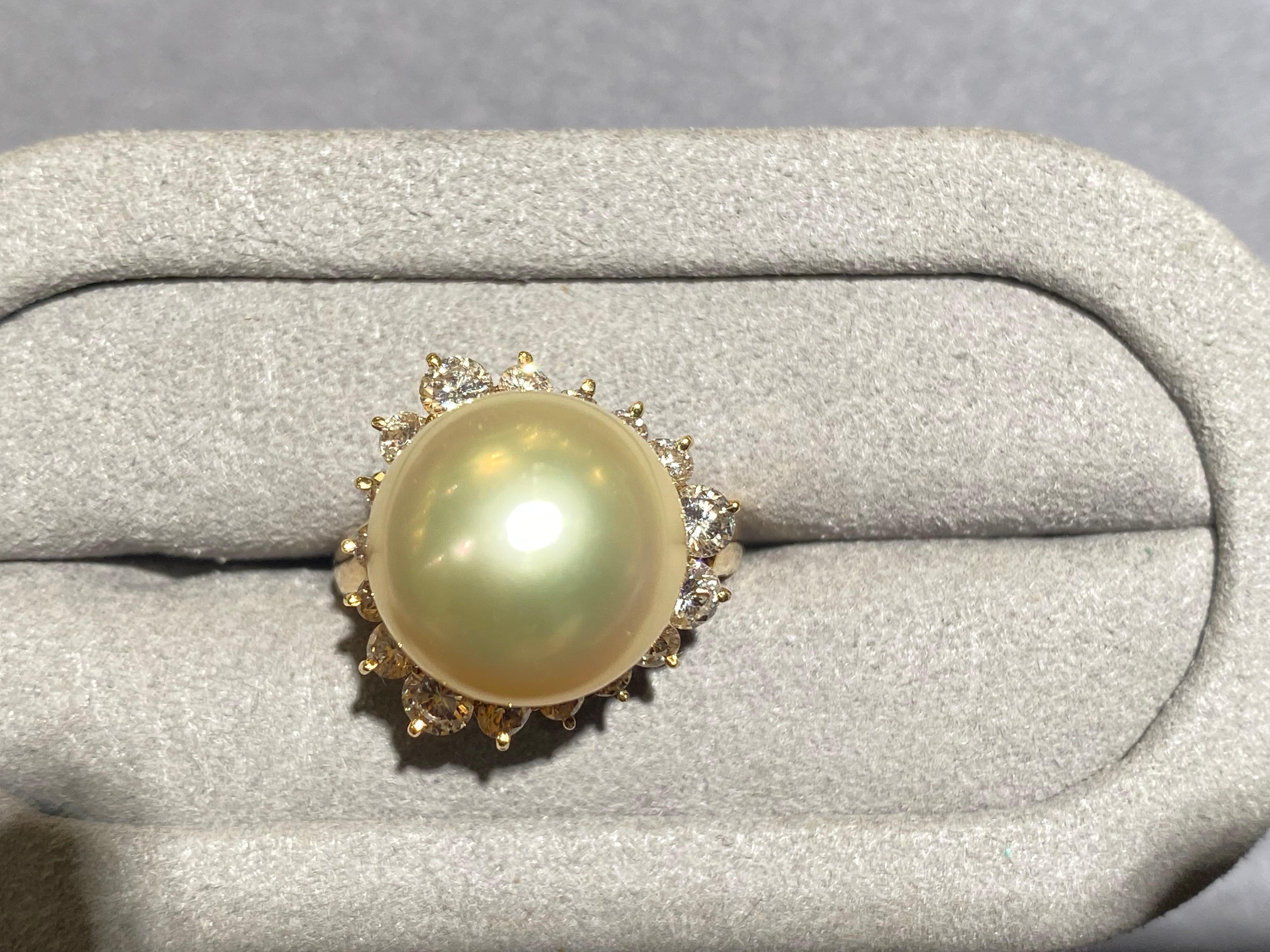 A light champagne colour south sea pearl and diaond ring in 18k yellow gold. The south sea pearl is round in shape and measuring 13.7 mm. The pearl is set in the middle of the ring and is surrounded by a circle of diamonds. This is a modified