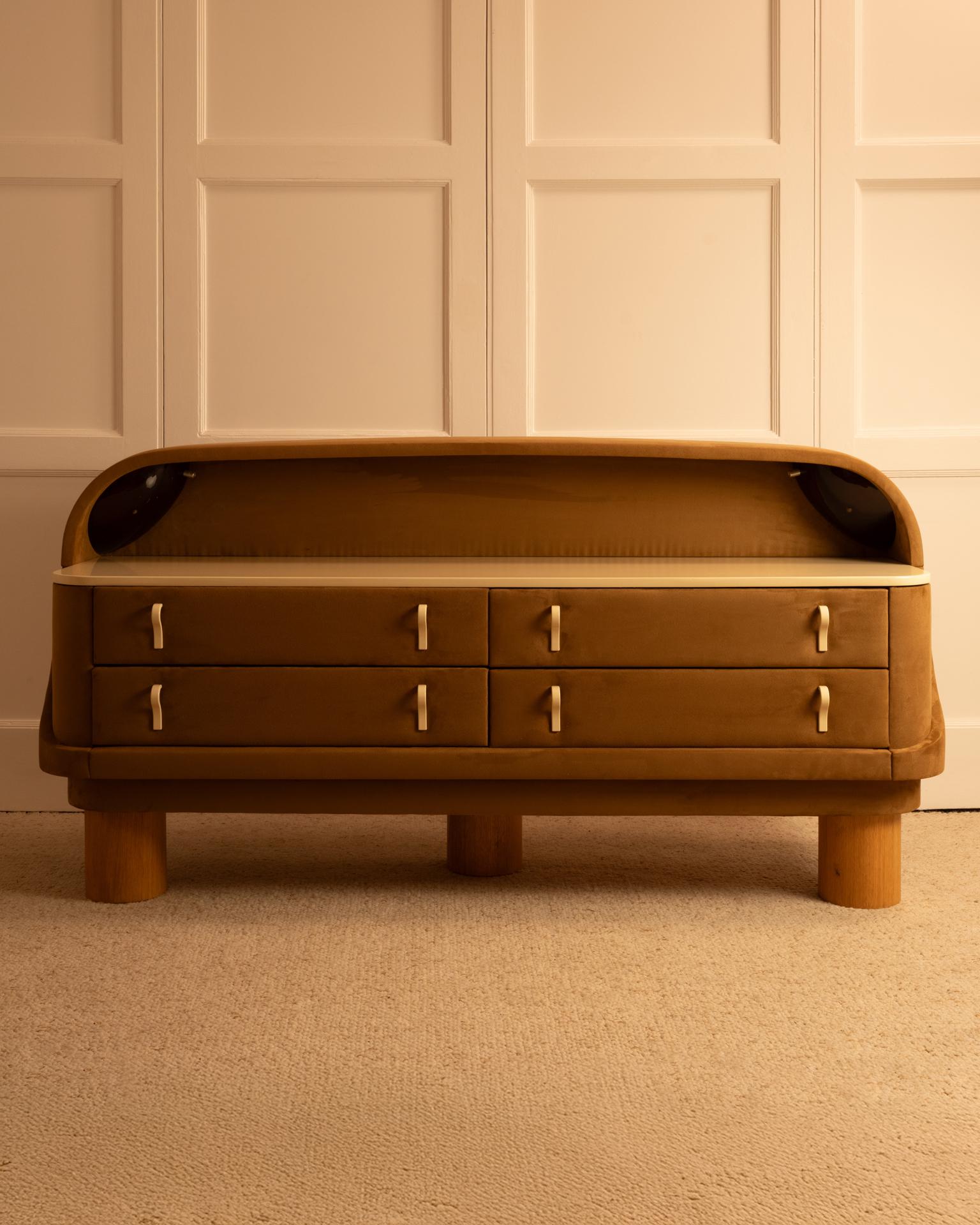Cómoda iluminada - Italia, Años 70

Cómoda iluminada con estructura de madera y tapicería de ante marrón. Asas y parte superior lacadas en crema. Cajones de madera chapada.
Se han añadido tres patas de chapa de roble para añadir altura.
Una pieza