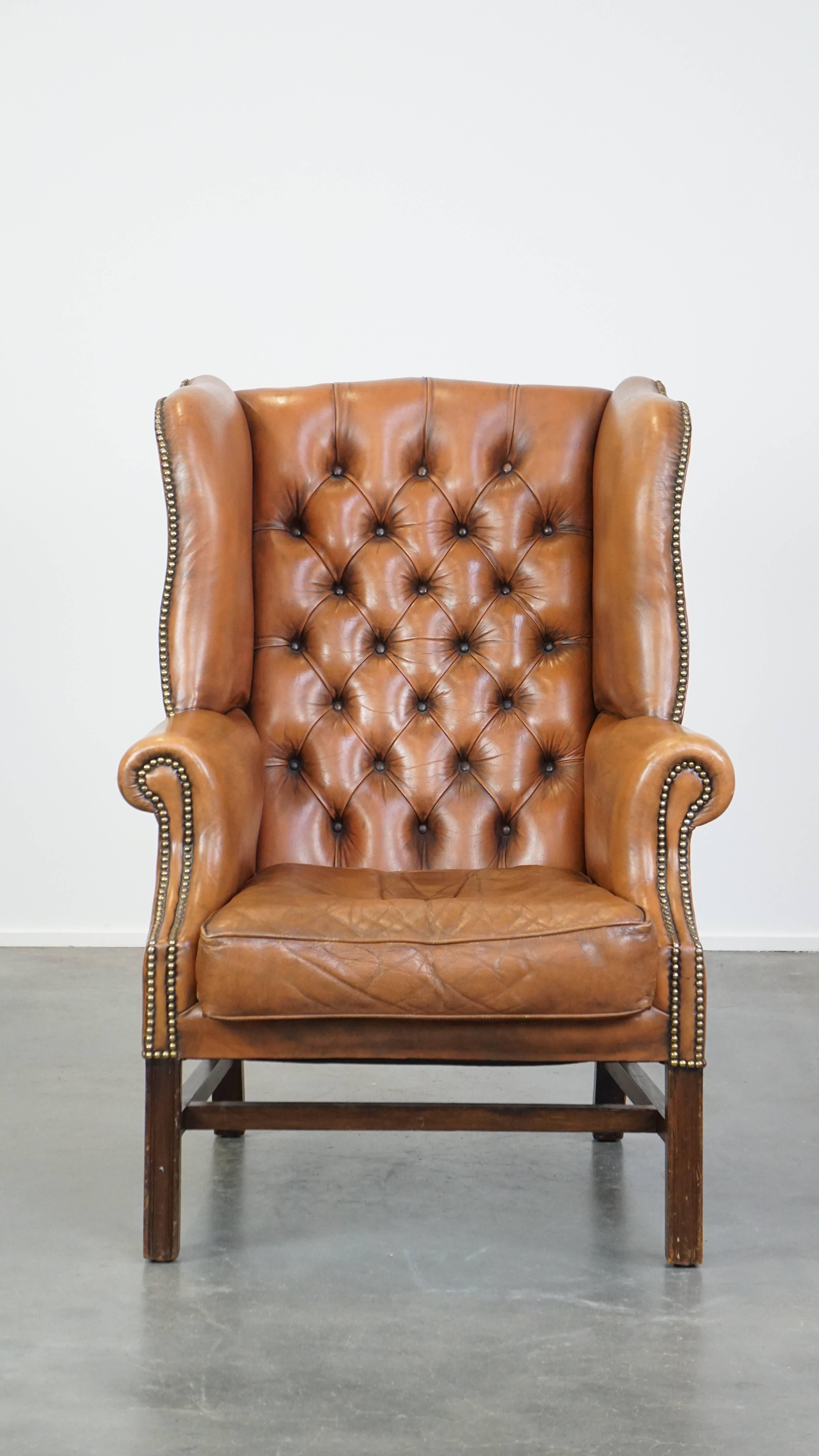 Luxe, caractère et style : ces trois mots décrivent parfaitement ce fauteuil à oreilles Chesterfield en cuir de vachette. Il se caractérise par une couleur cognac clair et un aspect distinctif. Avec son coussin d'assise lâche et son dossier fin, ce
