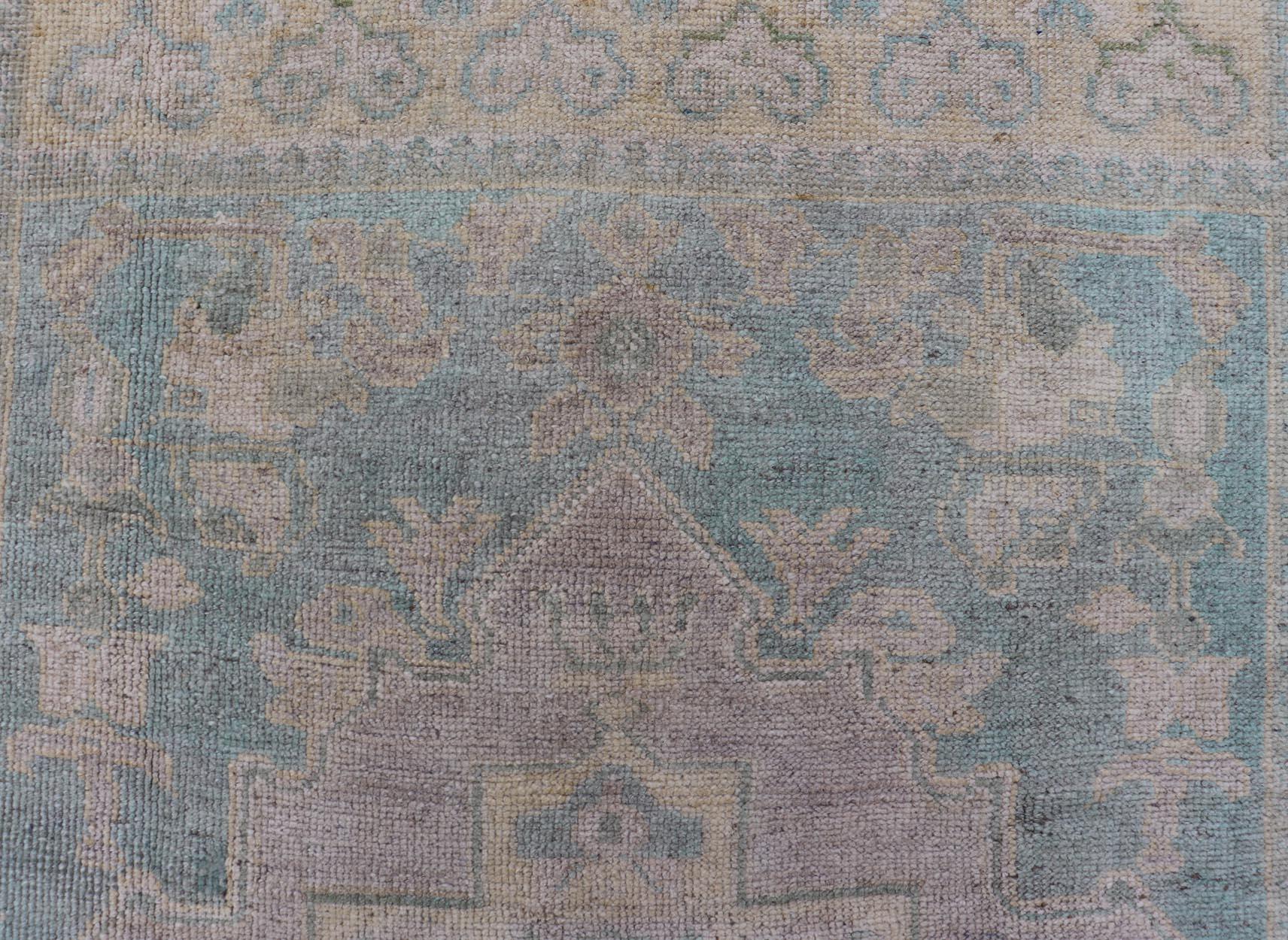 Measures: 4'10 x 7'0 

This vintage Turkish Oushak features a large central medallion and a complimentary stylized border. The charming palette consists of muted shades of blue, pink, orange, and green. 

Country of Origin: Turkey; Type: Oushak;