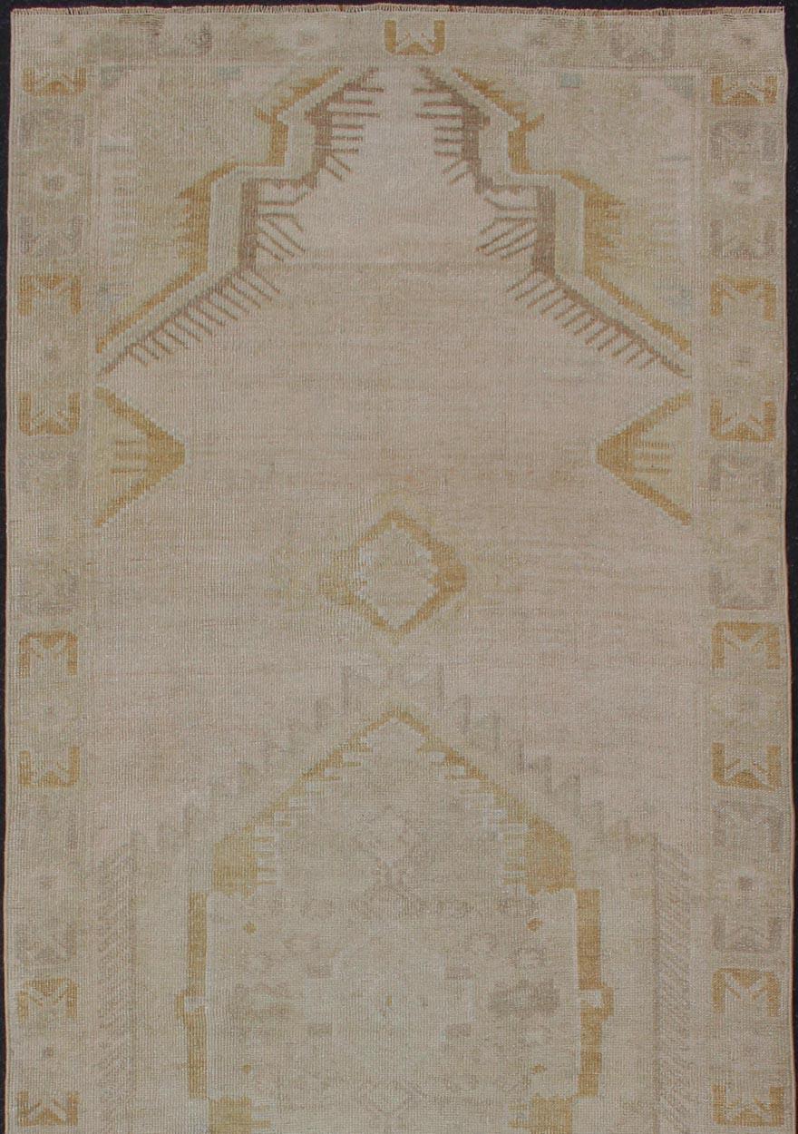 Medallion Oushak Gallery carpet, Keivan Woven Arts / rug TU-ALK-3552, country of origin / type: Turkey / Oushak, circa 1940. Light colored vintage Oushak runner with geometric medallions

This Oushak Gallery carpet from mid-20th century Turkey