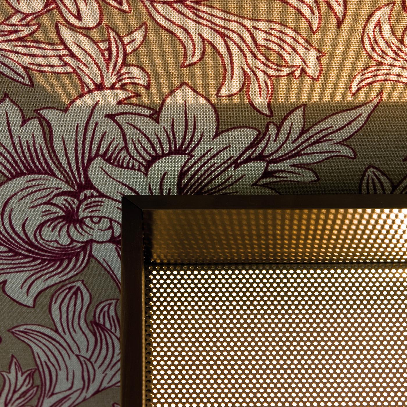 This striking table lamp has an aluminum structure covered with burnished brass sheets and a diffusor in micro-perforated stainless steel. The cubic shape of this piece allows it to be place on a table or even the floor, since the light is projected