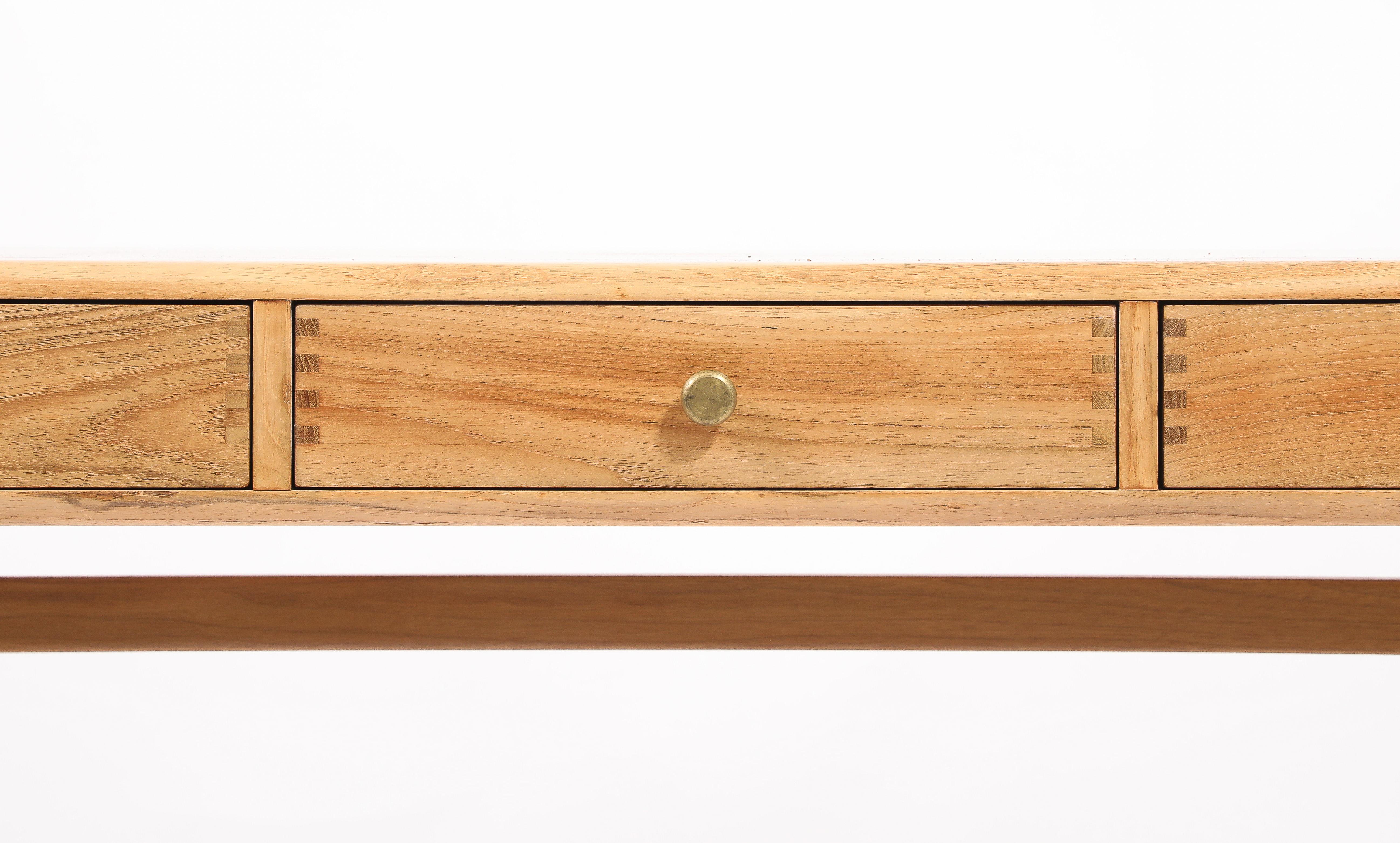 A bleached Teak desk with exposed joinery finished on all sides. Clearance under apron 24”.