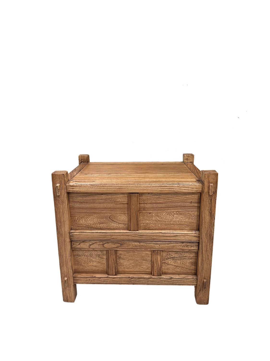 Questo moderno comodino organico, meticolosamente realizzato in legno di olmo di alta qualità, combina funzionalità ed eleganza naturale. Grazie alle tonalità calde e ricche del legno e alle venature distintive, questo pezzo emana un fascino rustico