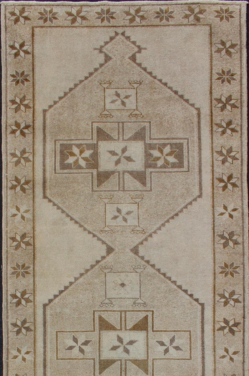 Medallion oushak gallery carpet, rug TU-ALK-3557, Keivan Woven Arts / country of origin / type: Turkey / Oushak, circa 1940. Light colored vintage Oushak runner with geometric medallions

This Oushak carpet from mid-20th century Turkey features a