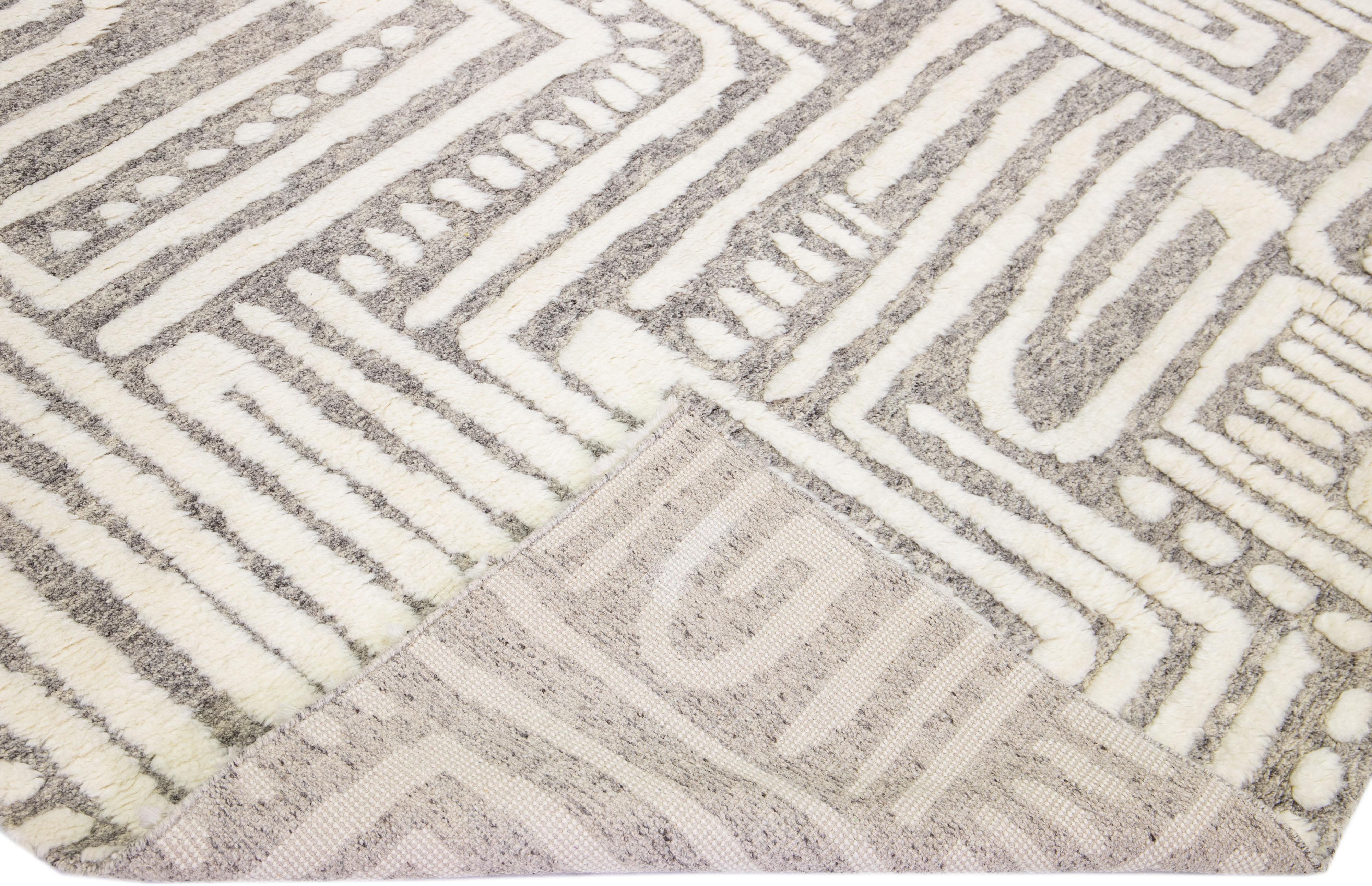 Beautiful modern Moroccan style hand-knotted wool rug with a light gray color field and ivory accents in a gorgeous abstract high pile design.

This rug measures: 9'10
