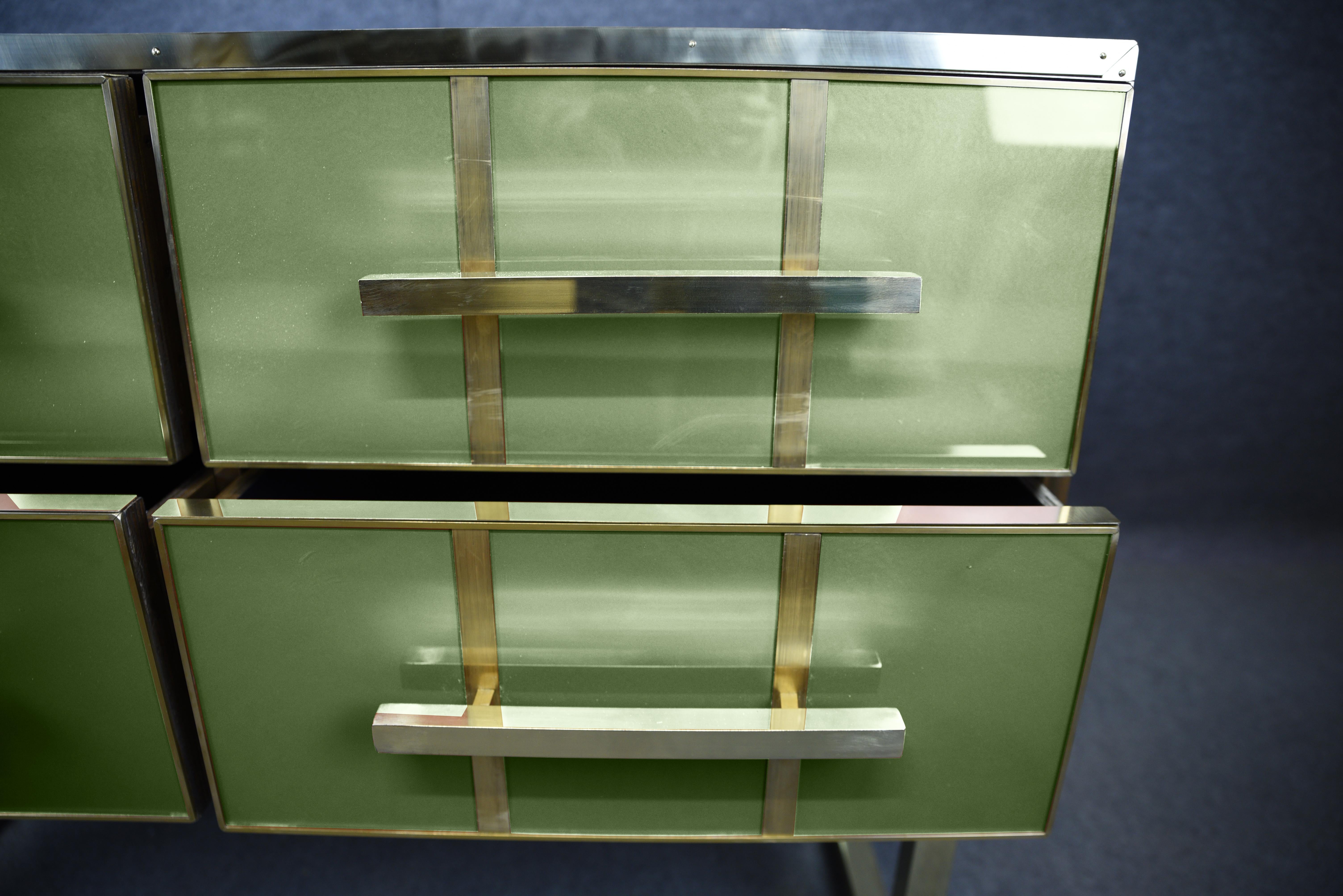 This Italian chest of drawers is a stunning mid-century modern piece, combining solid wood with Murano glass and polished brass accents. 

Handmade using traditional techniques such as painting, carving and soldering, it features black velvet-lined