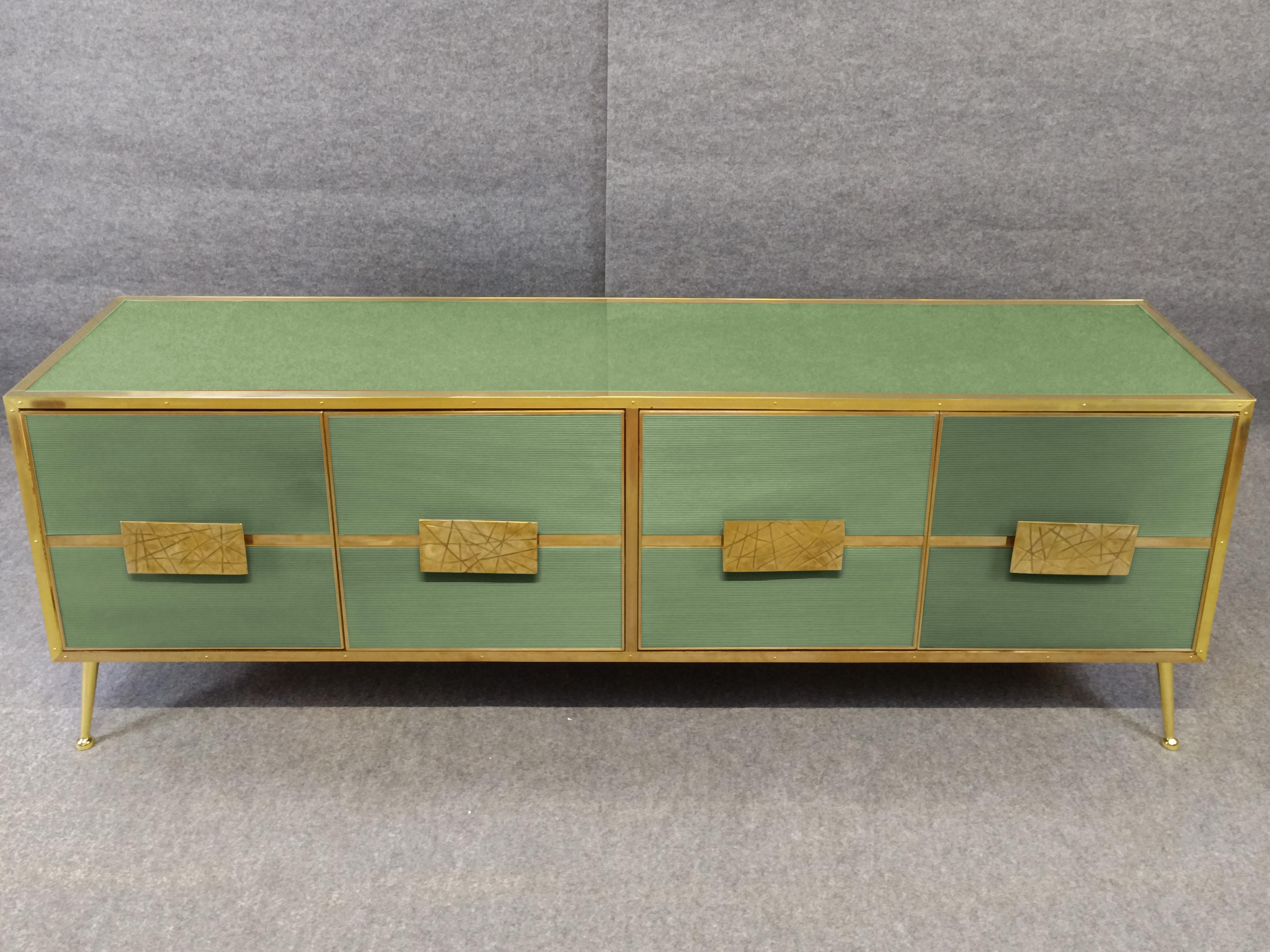This exquisite Italian sideboard in light green birch is a masterpiece of mid-century modern design. 

Handcrafted with meticulous attention to detail, it features four beautiful ‘Grisinato’ Murano glass doors with intricate patterns. 

The