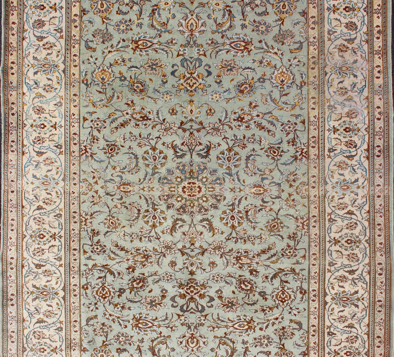 Ivory, cream, light green, red, yellow and light blue vintage Persian Kashan rug with all-over blossom design, rug / H-604-21 country of origin / type: Iran / Kashan, circa 1950.

A pale green sets the attractive background which is outlined by many