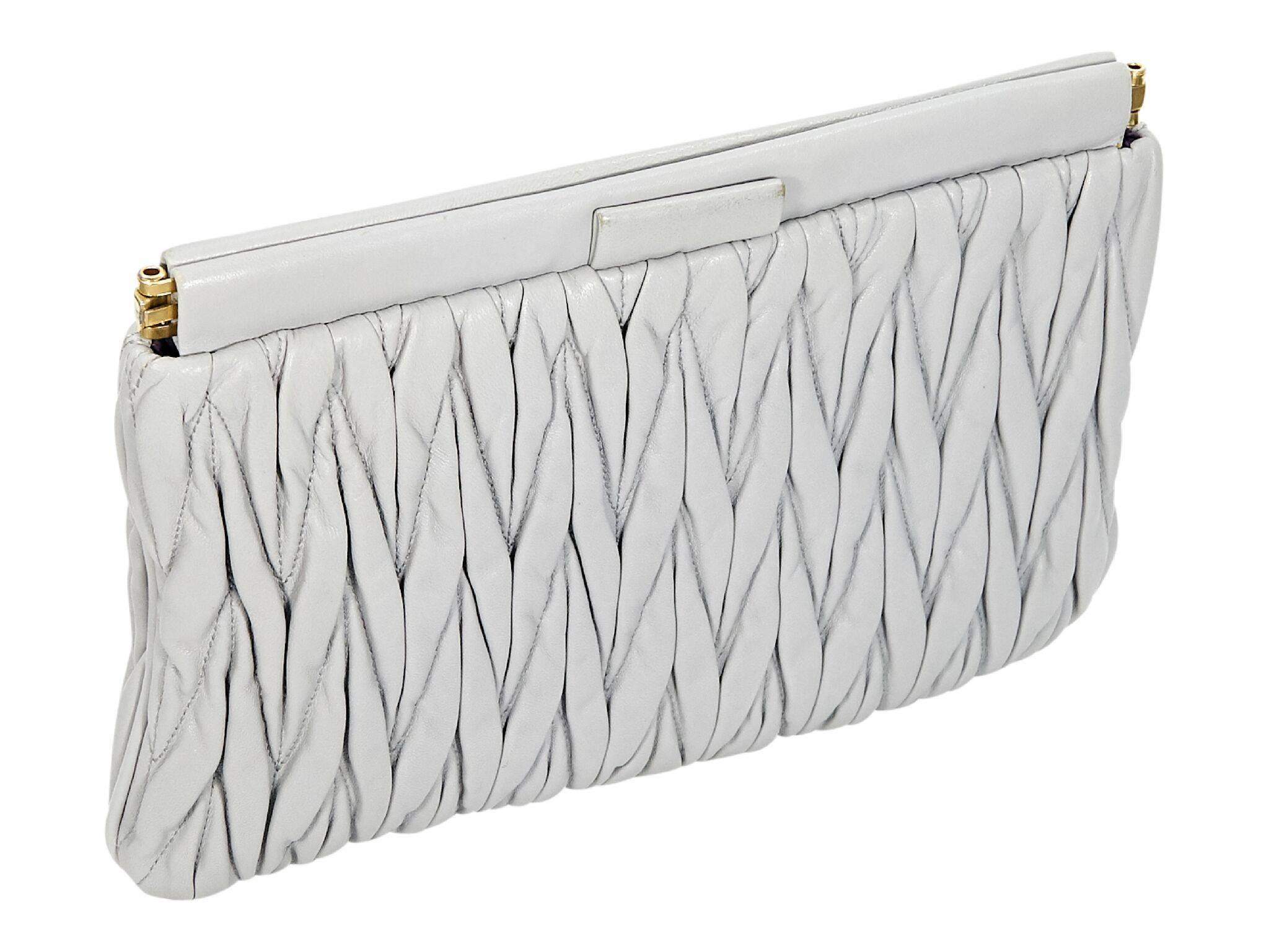 Product details:  Light grey leather matelasse clutch by Miu Miu.  Hinged top closure.  Lined interior with inner slide pocket.  Goldtone hardware.  11
