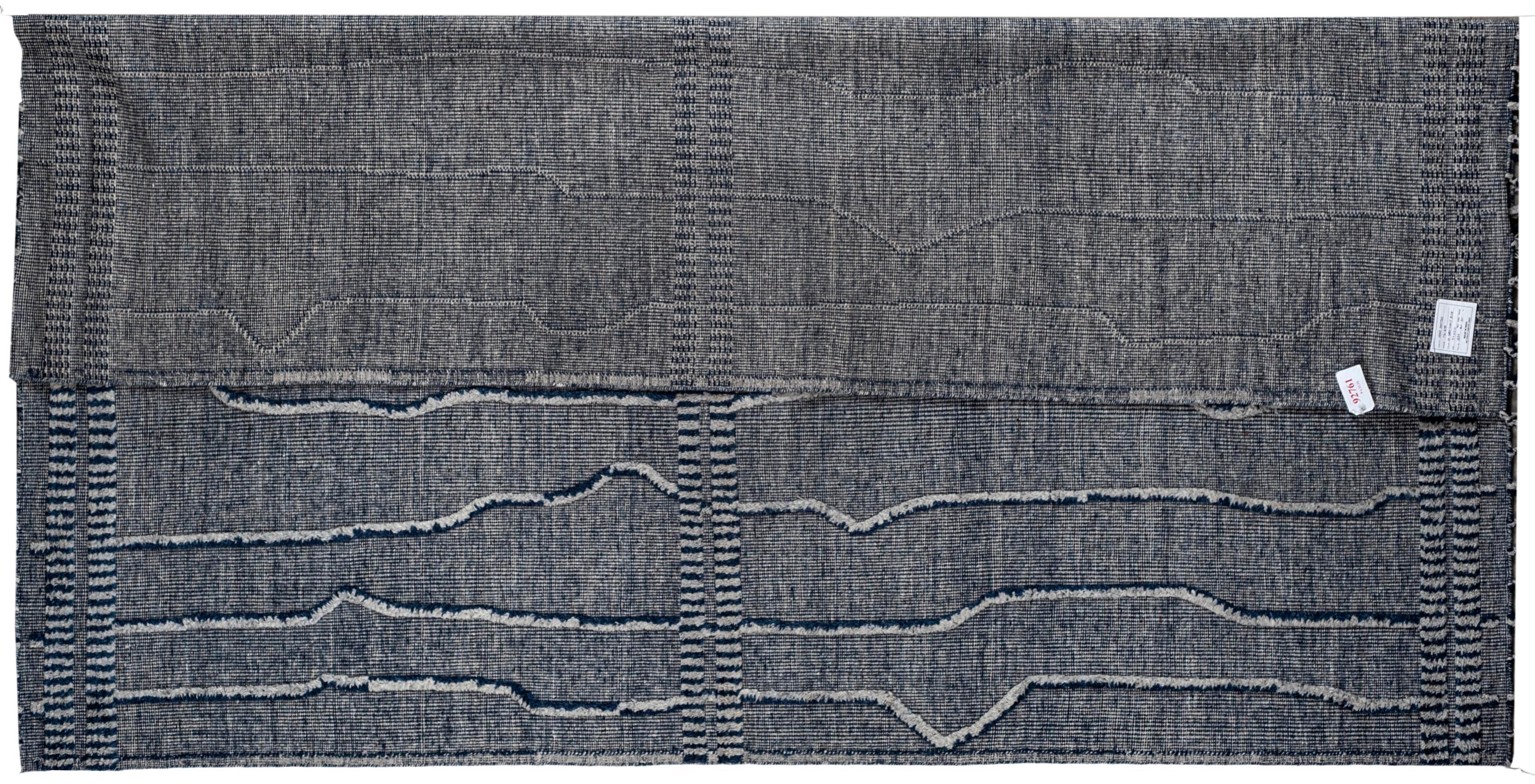 Questo tappeto a righe marocchine di circa 12 x 15, di colore grigio chiaro e blu marino, è realizzato a mano e annodato a mano in India. Ha una base di cotone ed è realizzato con filati di lana. Caratterizzato da una composizione contemporanea di