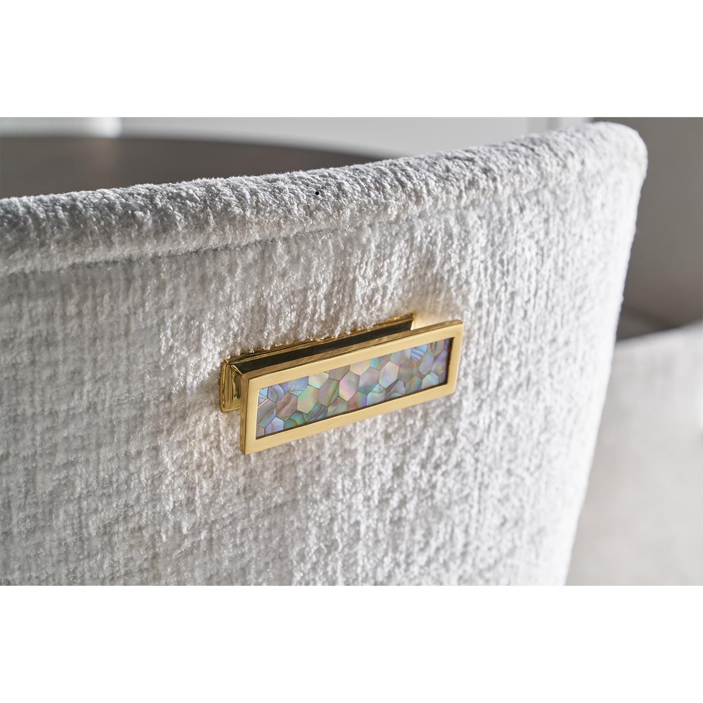 Le fauteuil rembourré apporte une douceur élégante à tout décor de salle à manger. Le dossier et l'assise sur capitonnés sont conçus pour le confort et le style, créant un profil sculptural à la fois raffiné et accueillant.

Les pieds en bois