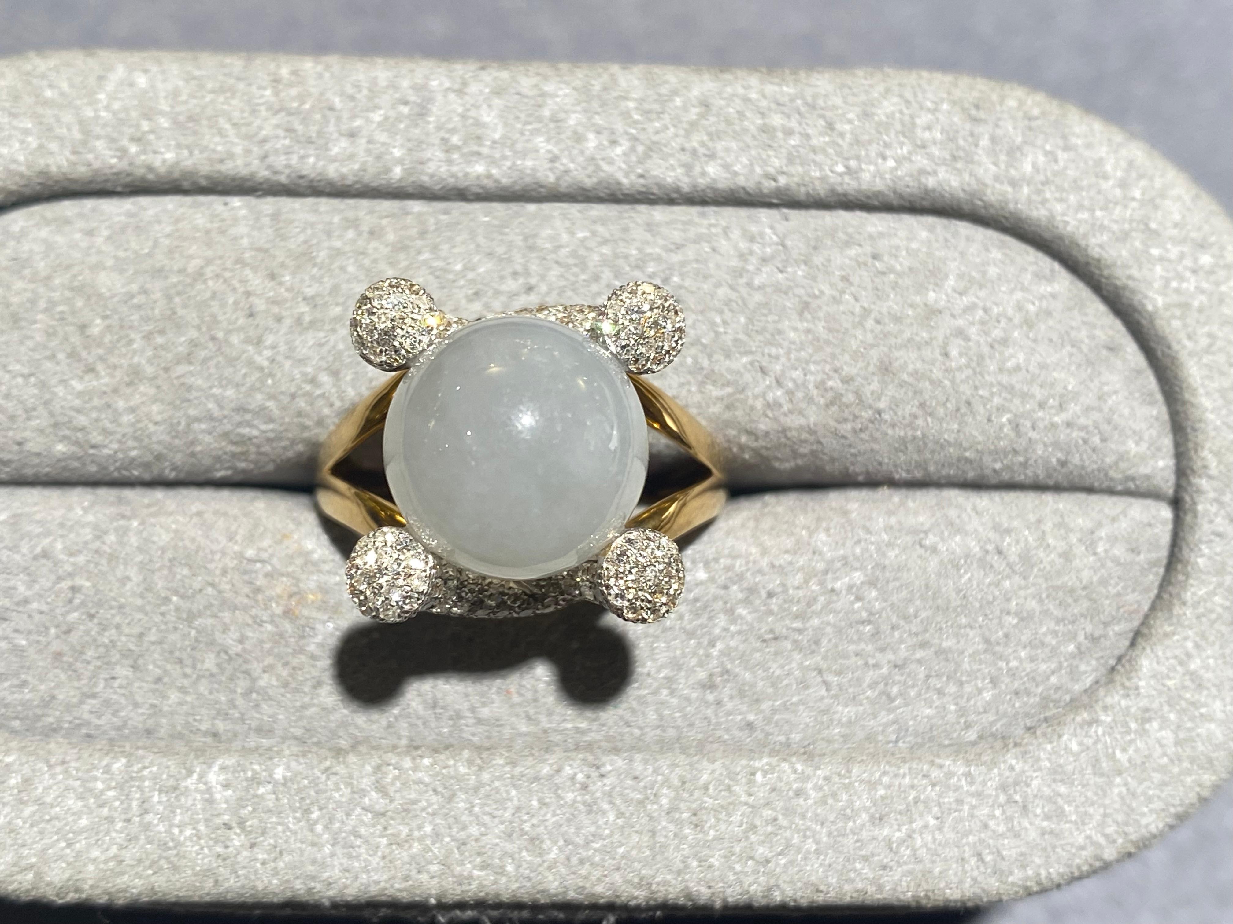 A light lavender colour type A jadeite and diamond ring in 18k yellow gold. The jadeite is in the bead form and is set between 2 diamond encrusted horn-like structure. This is a very unique and fashionable design but is also suited for everyday