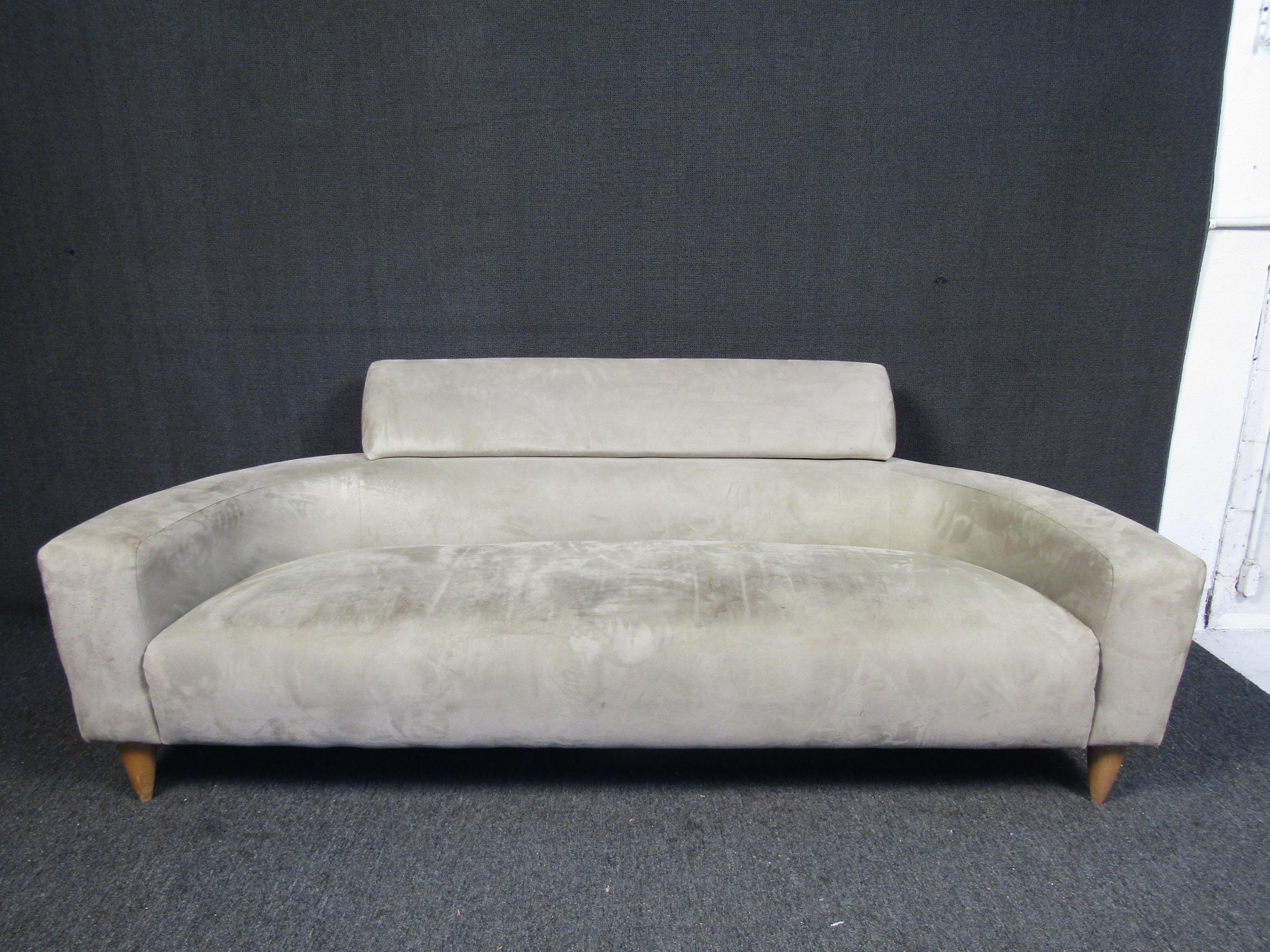 This long and low vintage Mid-Century Modern sofa is fitted with soft bright colored fabric and sleek walnut legs. The modern design is what gives the sofa its distinctive look. Please confirm item location (NJ or NY).