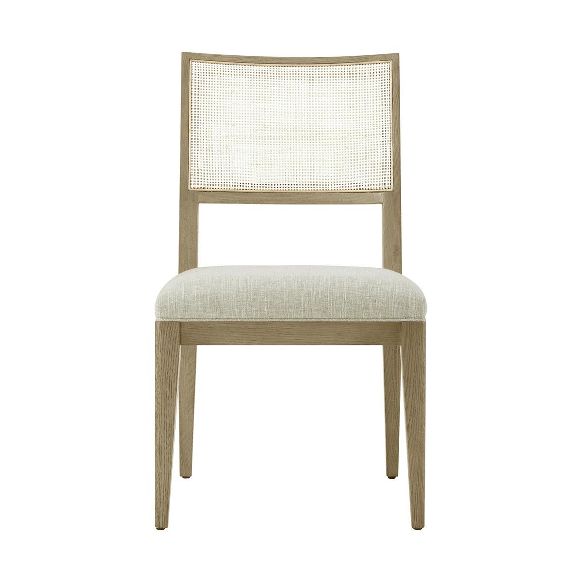 Dining Side Chair, a solid frame in our light dune finish, with a curved and caned backrest, a padded and upholstered seat cushions raised on tapered legs.

Dimensions: 20