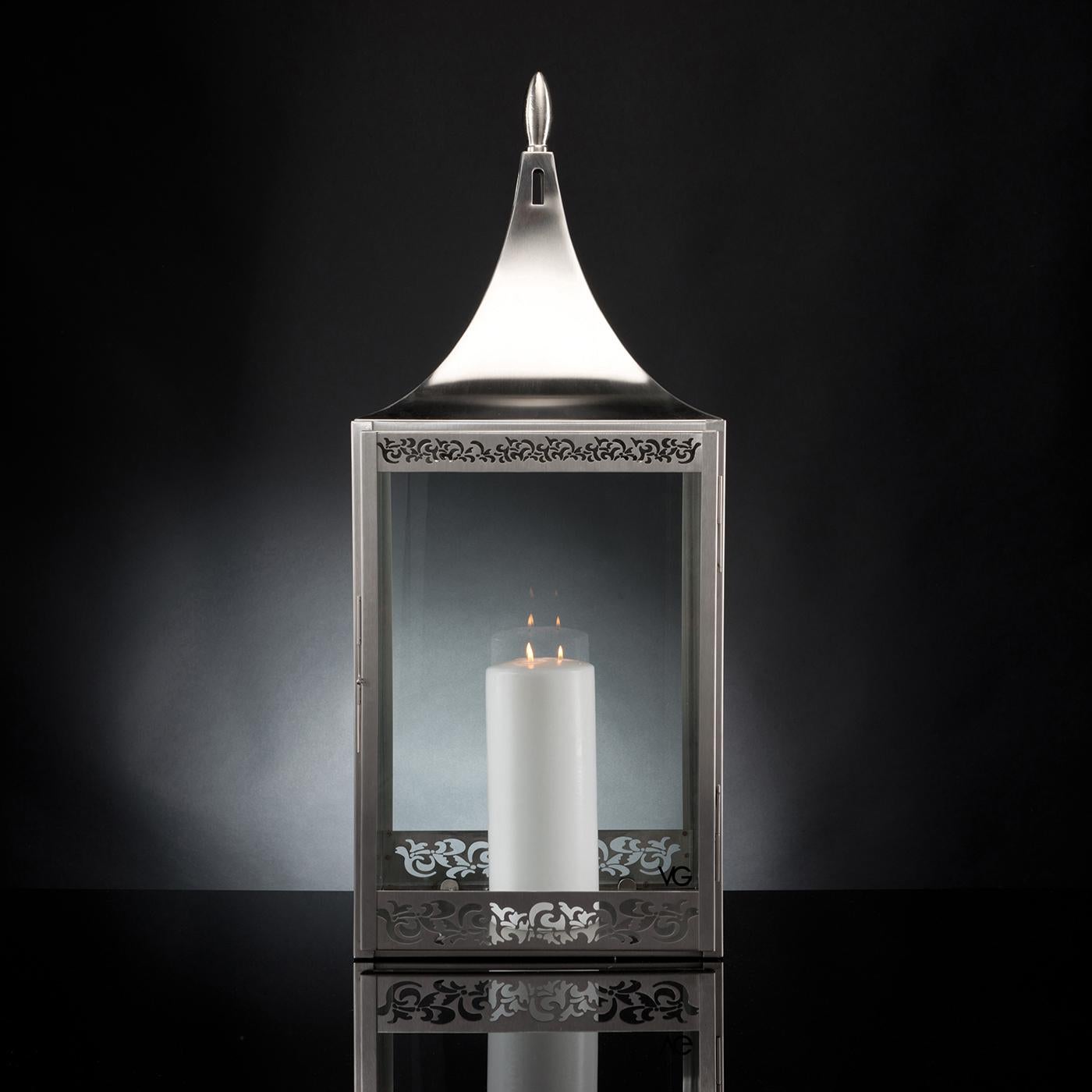 An exquisite showcase of craftsmanship, this lantern is handmade of satin-finished steel. A modern piece of ancient inspiration, it is adorned with a superb floral motif boasting strong visual and textural value enhancing its profile. The piece is