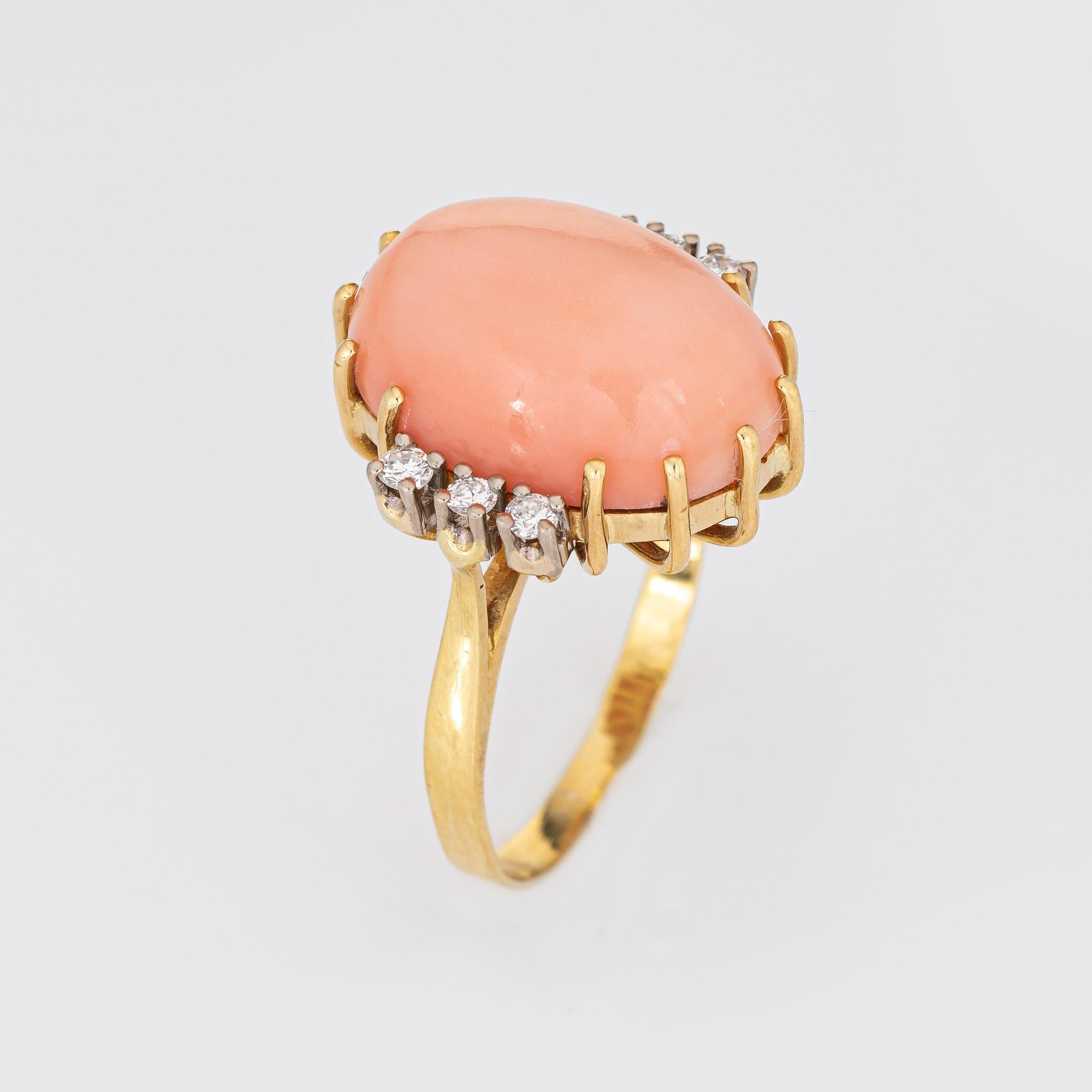 Stylish vintage coral & diamond cocktail ring (circa 1970s) crafted in 18 karat yellow gold. 

Coral cabochon measures 10mm x 7mm (estimated at 7 carats). Six diamonds total an estimated 0.18 carats (estimated at H-I color and VS1-2 clarity). The