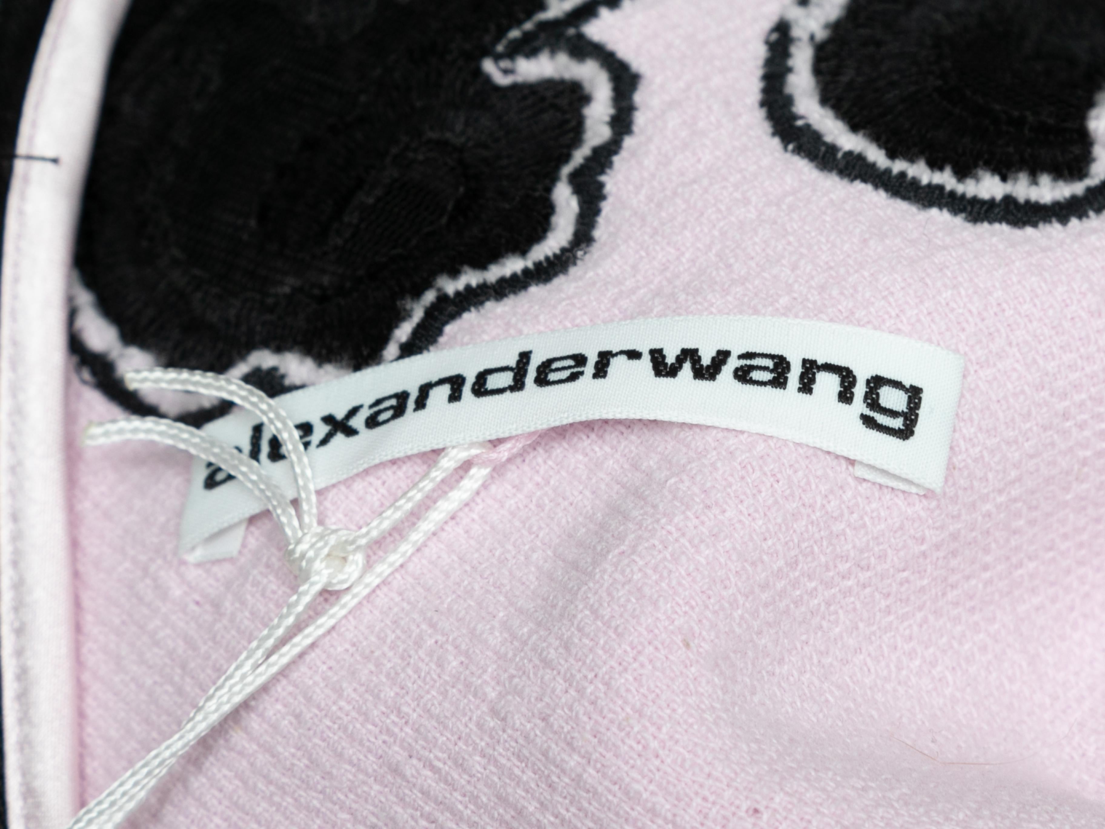 Mini robe sans manches en tissu éponge rose pâle et noir et en dentelle brodée, signée Alexander Wang. Décolleté en cœur. Bretelles étroites. Fermeture à glissière au dos. Poitrine 32