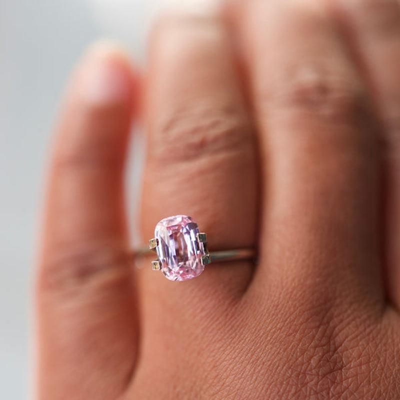 A large soft warm light pink sapphire glistening rays of orangish pink light from angled facets from this cushion shaped sapphire of over 3 carat. Of Madagascan origin this natural light pink sapphire which is certified unheated would make a