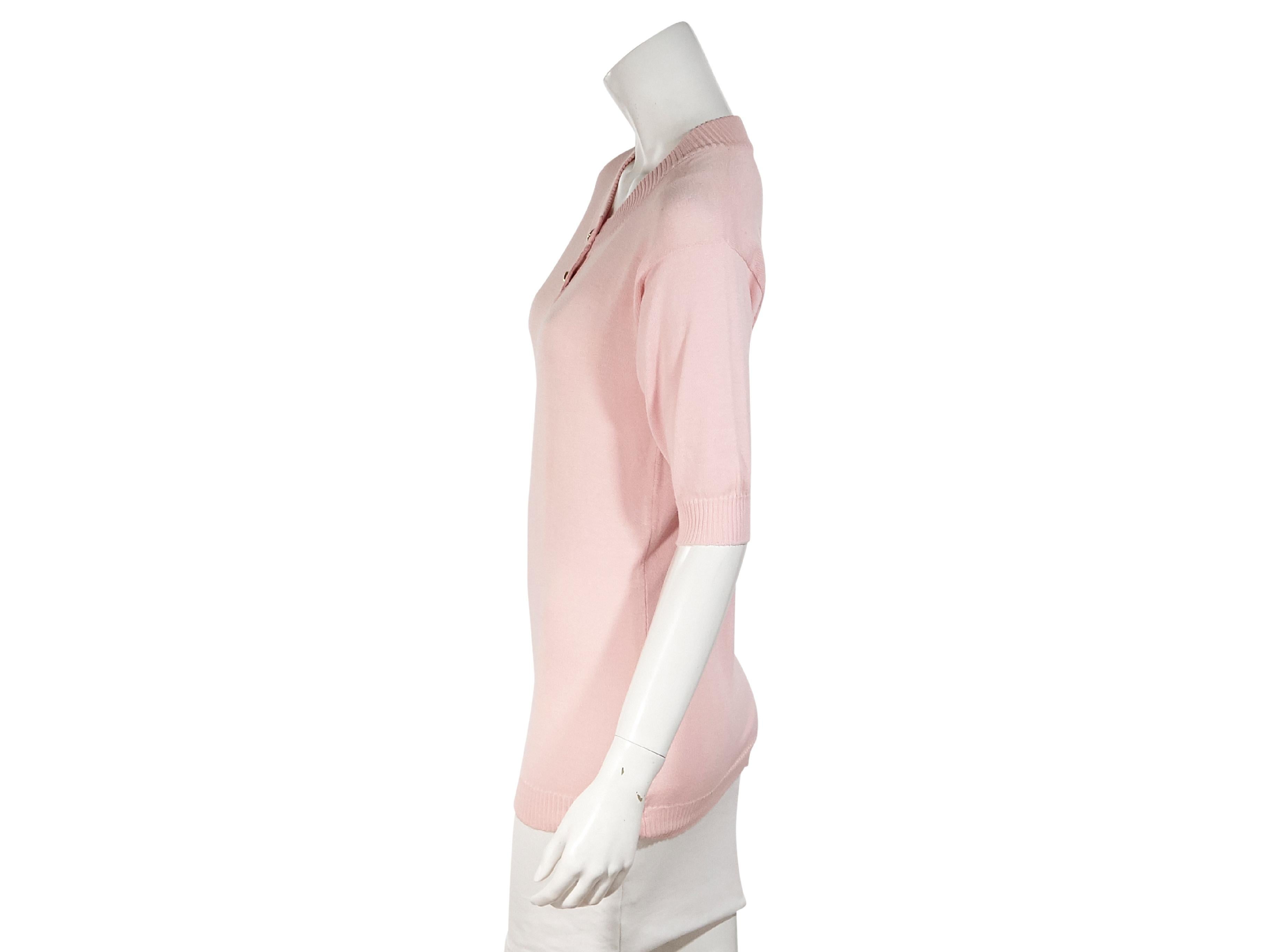 Product details:  Vintage light pink sweater top by Chanel.  Ribbed crewneck.  Short sleeves.  Two-button placket.  Ribbed hem.  Pullover style.  Goldtone hardware.  34