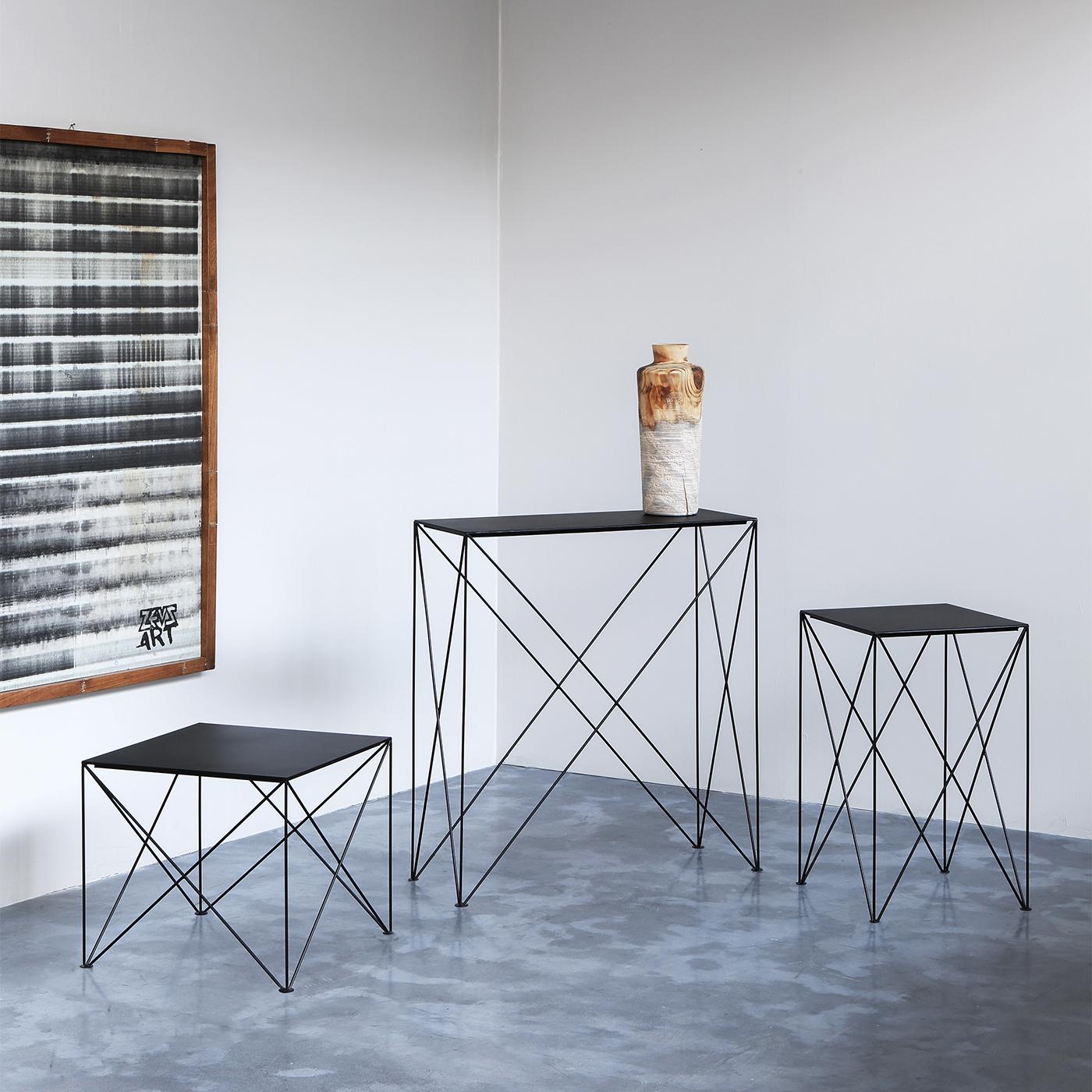 Airy and intriguing, this contemporary-style console is a clever synthesis between simplicity and dynamism. The lightweight metal frame, offered in a deep black finish and enriched with a sandblasted effect for enhanced refinement, comes complete