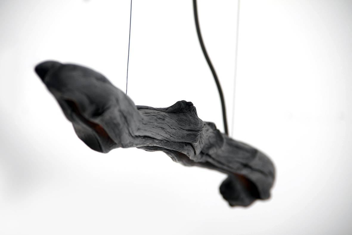 Light Suspension, Burning Ego by Wim Verzantvoort, WDSTCK Studio
Dimensions: 100 x 250 x 30
Adjustable height
Material: Burned oakwood

An observing walk through a forest can leave us feeling
free, serene and sheltered at the same time. Trees