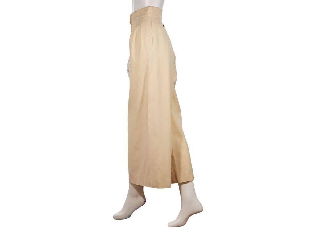 Product details:  Vintage light tan wide-leg pants by Chanel.  Banded waist with double button closure.  Pleats taper off waist.  Concealed button fly.  Back button pockets.  Label size FR 36.  32
