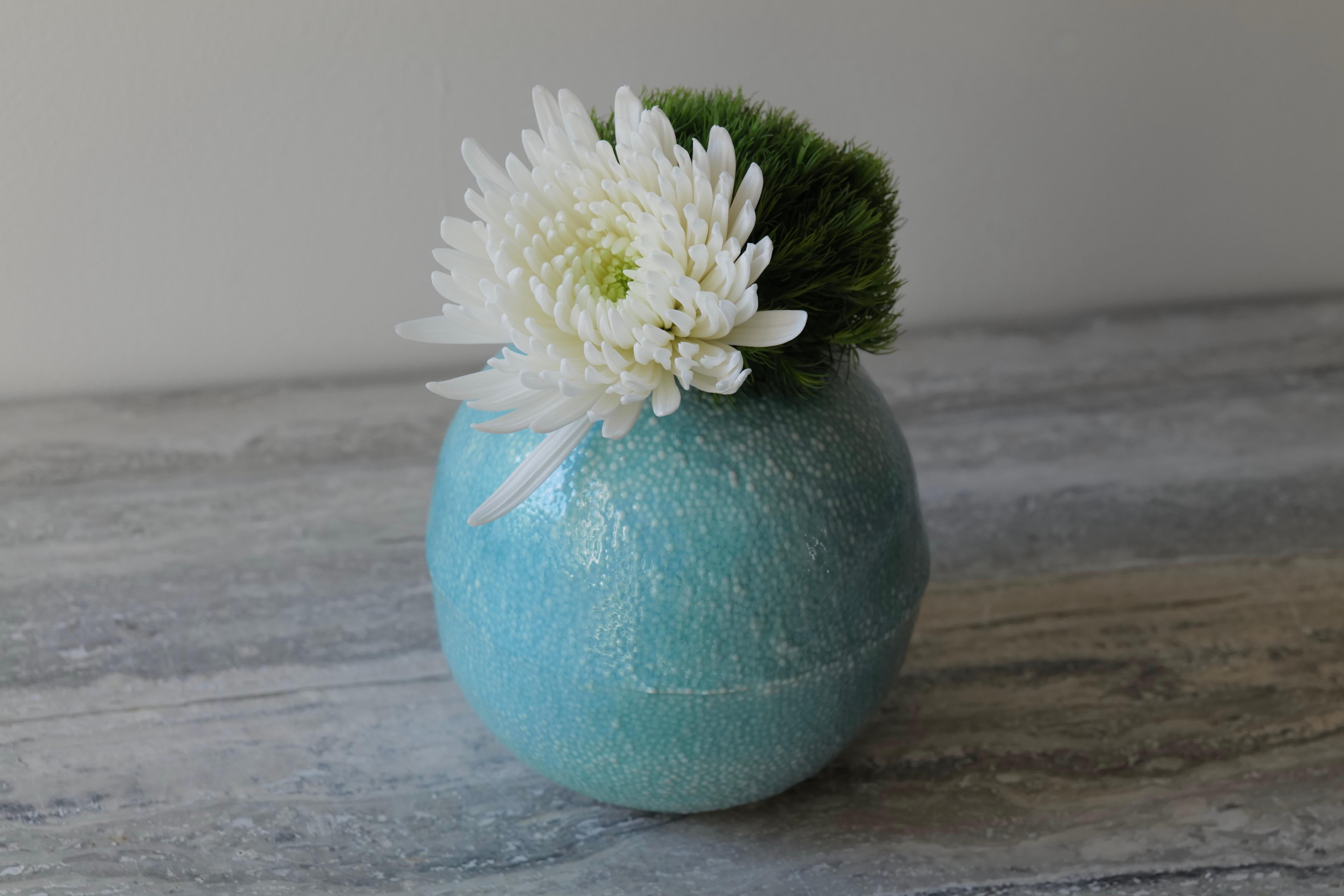 The Light Turquoise Caviar Porcelain Vessel radiates calm and refinement through its serene color and intricate texture. Slip cast in fine porcelain and finished with a delicate micro-textured surface, the vessel recalls the tactile rhythm of caviar