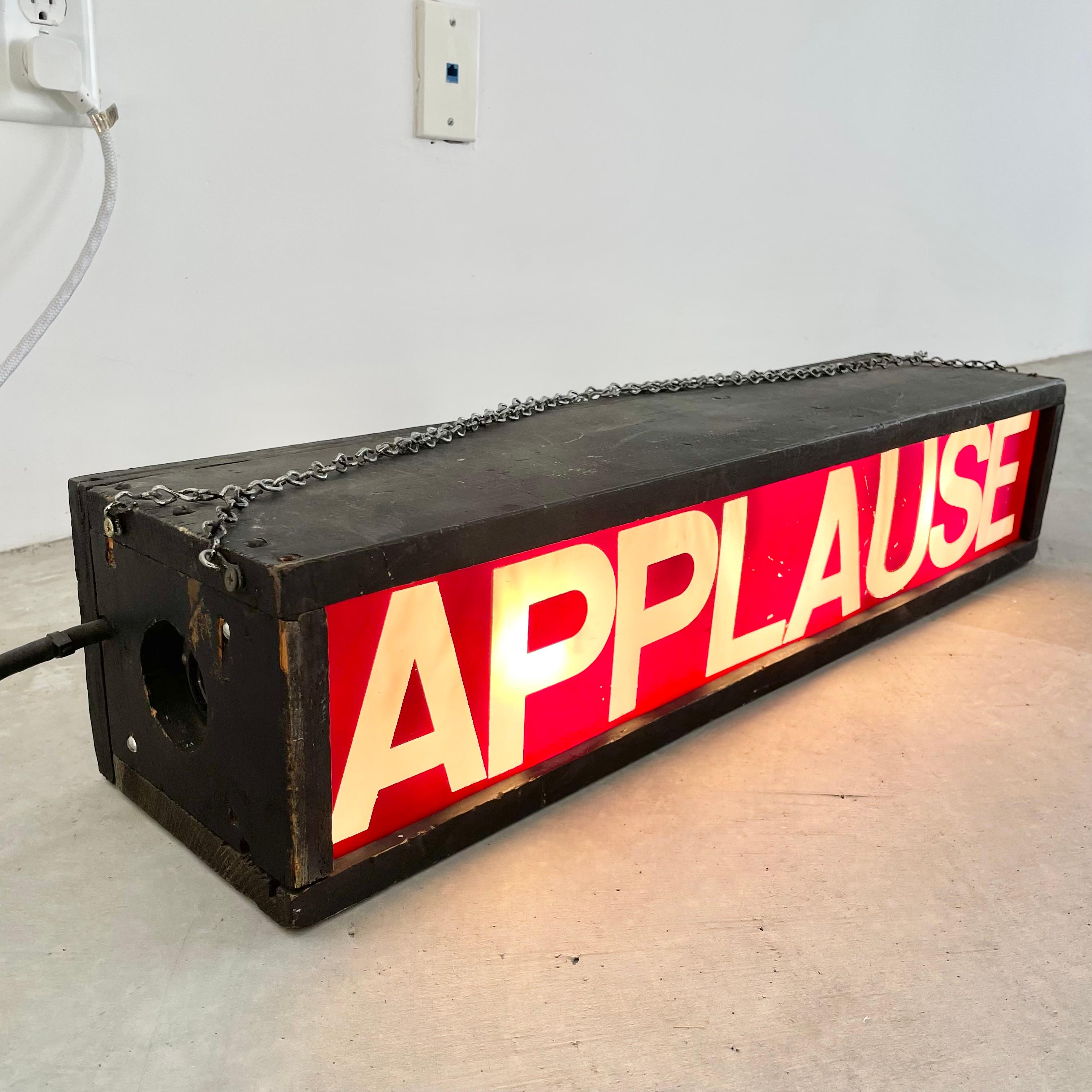 Vintage film studio sign from Los Angeles. 28 inches long. Wooden light box painted in a matte black with red and clear acrylic APPLAUSE sign. Fluorescent light inside. Used in a live studio telling the audience when to applaud. Sticker on the back