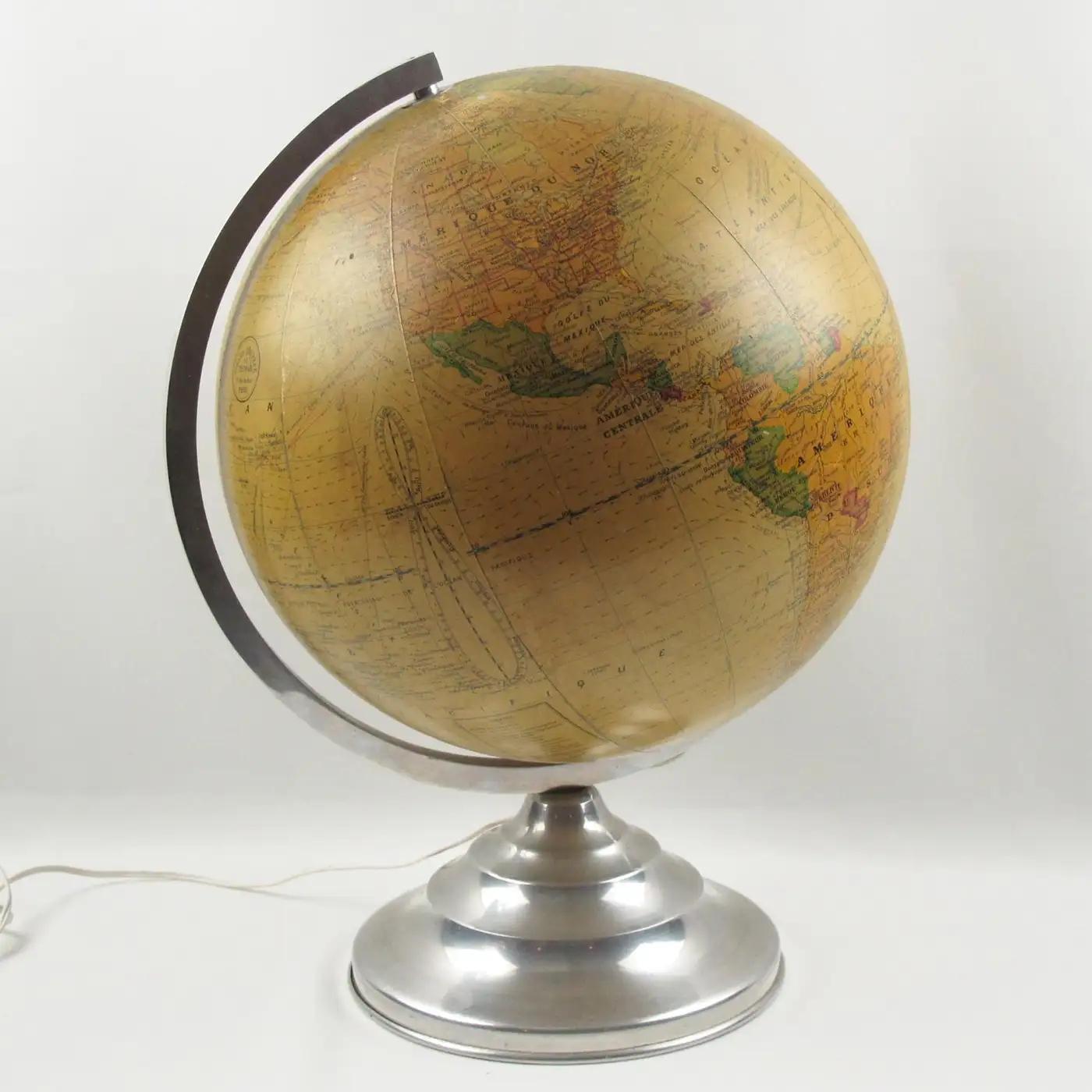 Girard, Barrere, and Thomas Paris manufactured this impressive terrestrial light-up globe in the 1950s. Geographer J. Forest designed it. This library glass globe is covered with print paper rotating on a chromed metal and aluminum stand. Besides