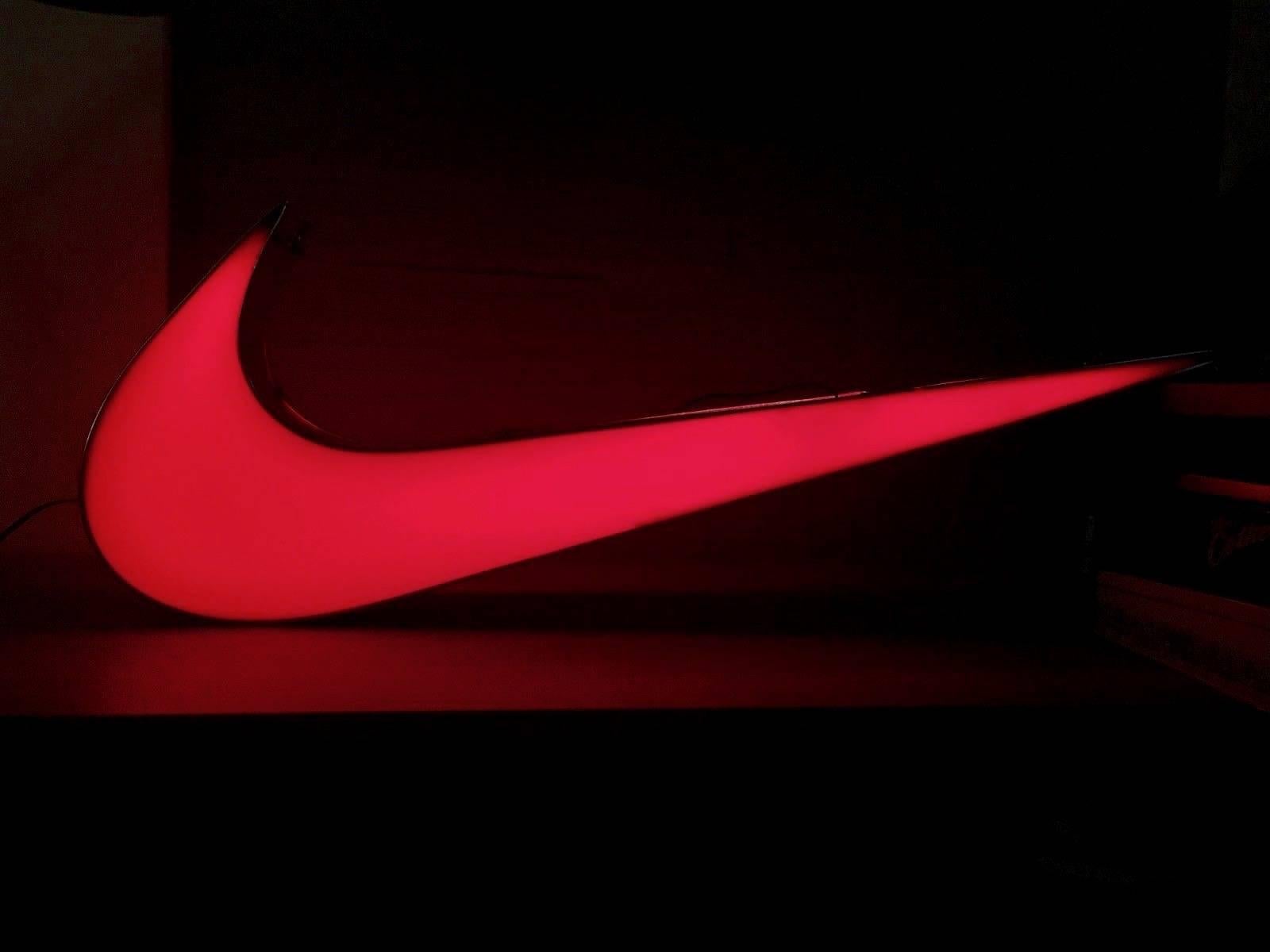 Massive illuminated metal and plastic Nike swoosh. Measures: 3 feet wide. Double sided. Was probably hanging in a Nike Store at some point. Large scale. Excellent condition. One of the most recognizable logos on earth. Super unique.
