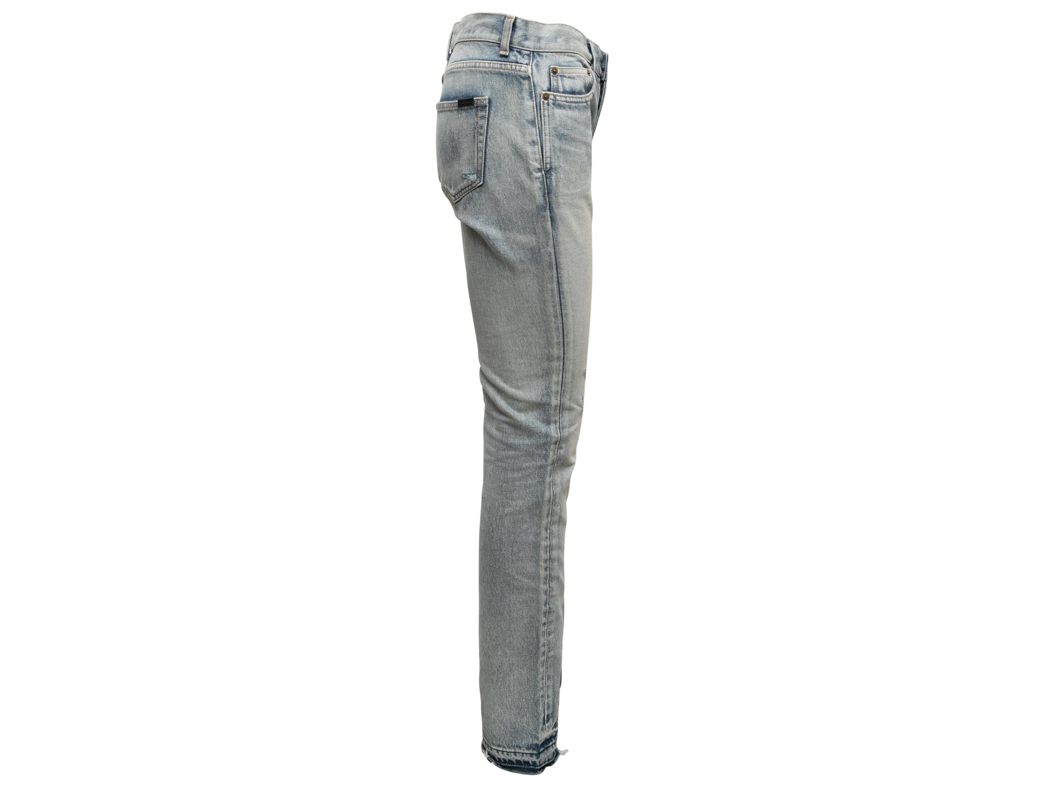  Light wash denim distressed skinny jeans by Saint Laurent. Five pockets. Zip and button closures at front. 31.5