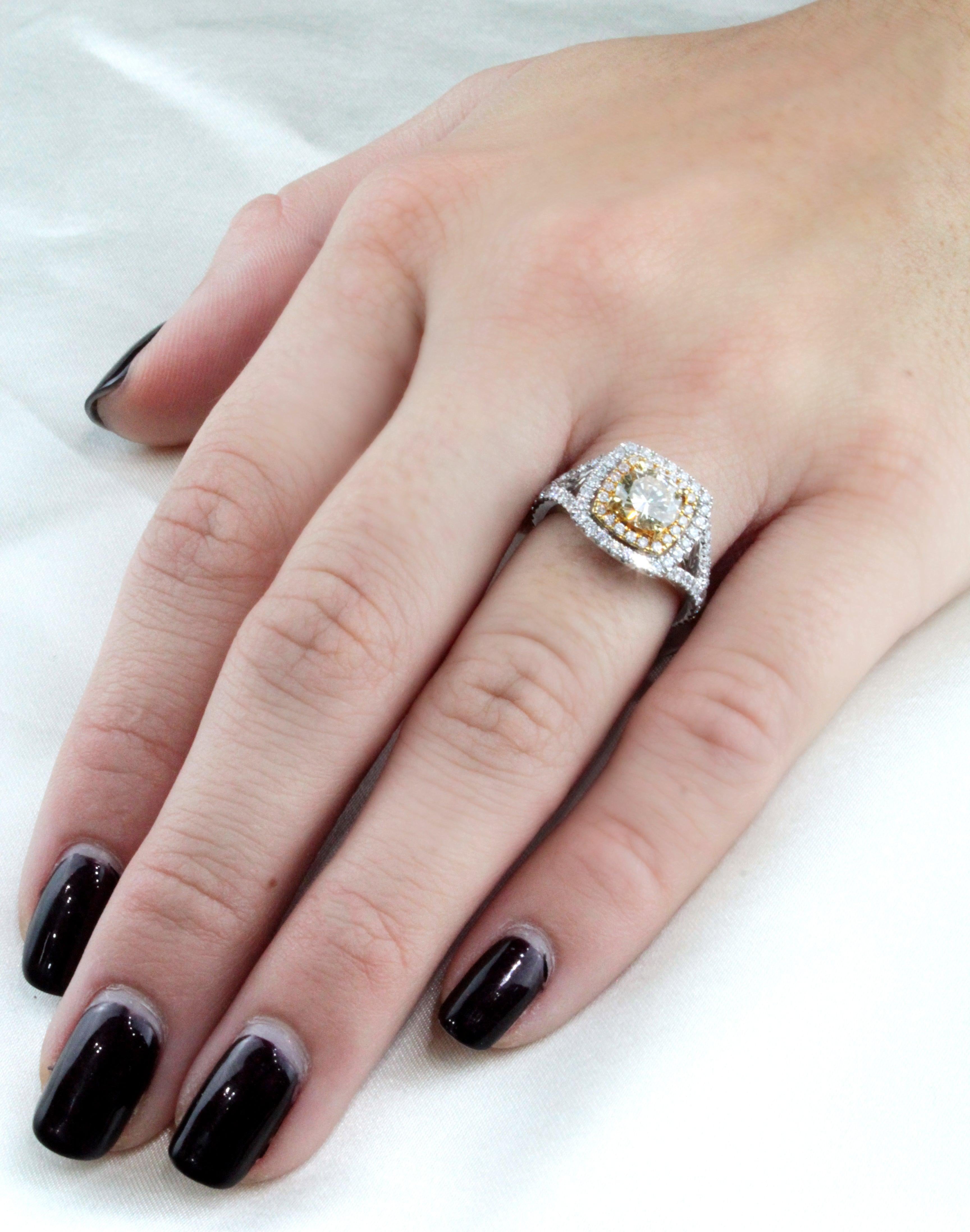 Engagement ring with light yellow diamond center stone, 1.03ctw set in 18 karat white gold with double halo. 60 round diamonds, 1.15ctw on the split shank and the halo. Size 6. 