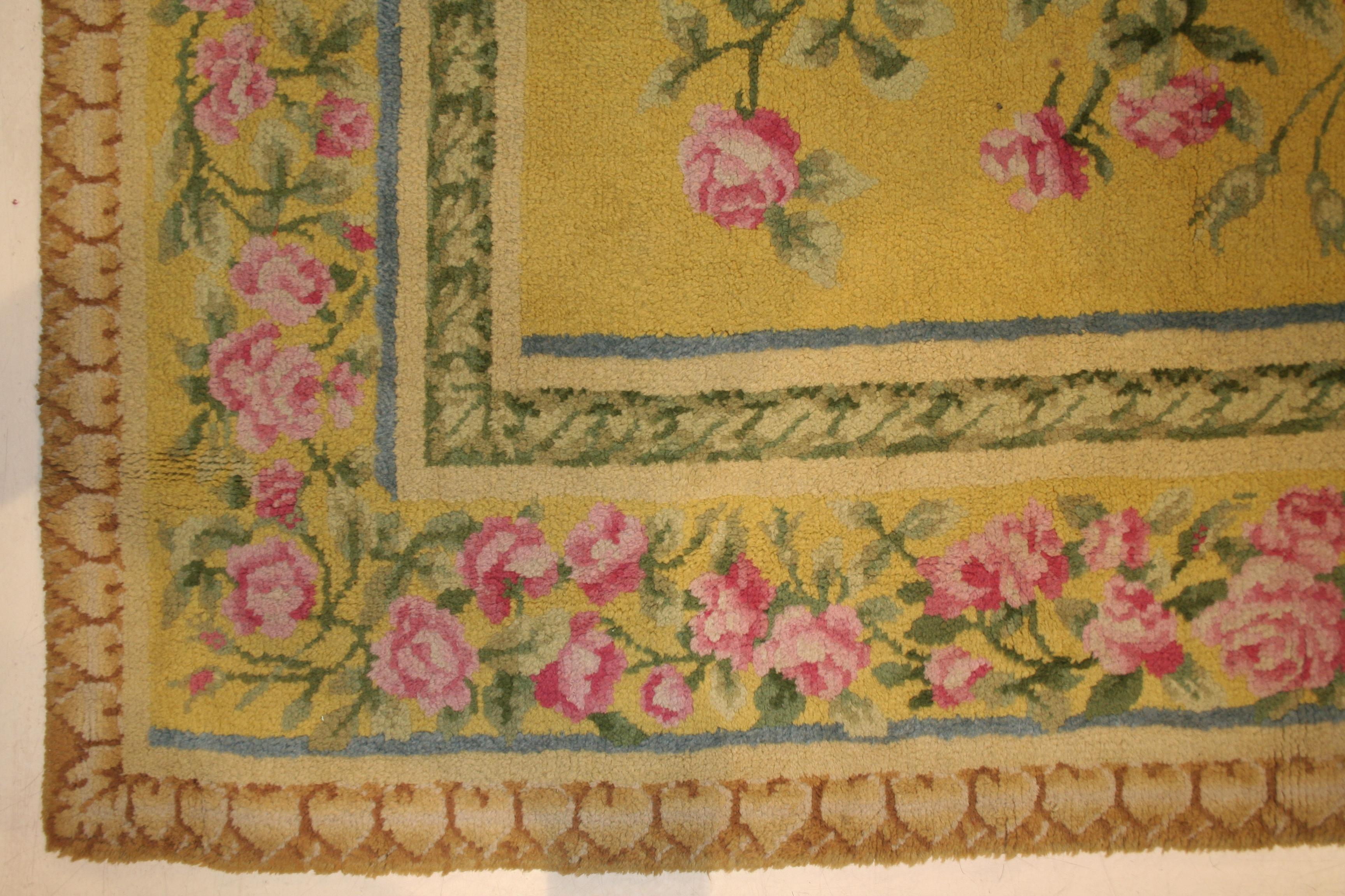 A truly elegant French Art Nouveau rug, characterized by a light yellow background filled with roses arranged on long stems which branch out to its sides and corners. The transition seen here from the formal, Rococo revival motifs of the late 19th