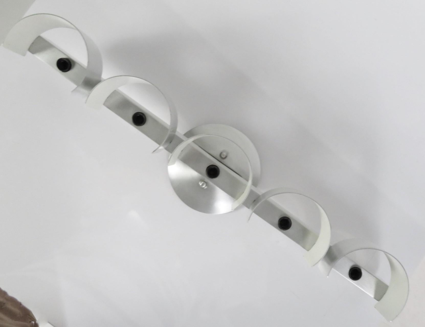 Vintage 1960s wall light in brush aluminum and semi-circle with the reflectible insides in white. Perfect for over the sink bathroom light or vanity. In very good condition, probably never used or used for a short amount of time. Very minor scrape,