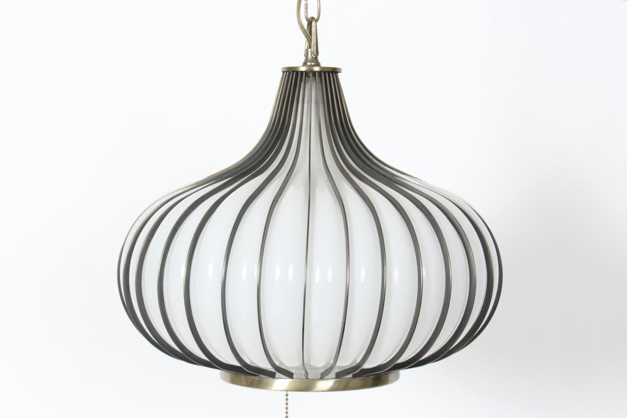 Colgante colgante California Modern White Glass Onion con marco de latón. Con forma de bulbo de ajo de cristal blanco soplado a mano, estriado en pátina de latón bronceado oscuro (Pantone 5535U) con casquillo y base de latón reflectante. Enchufe
