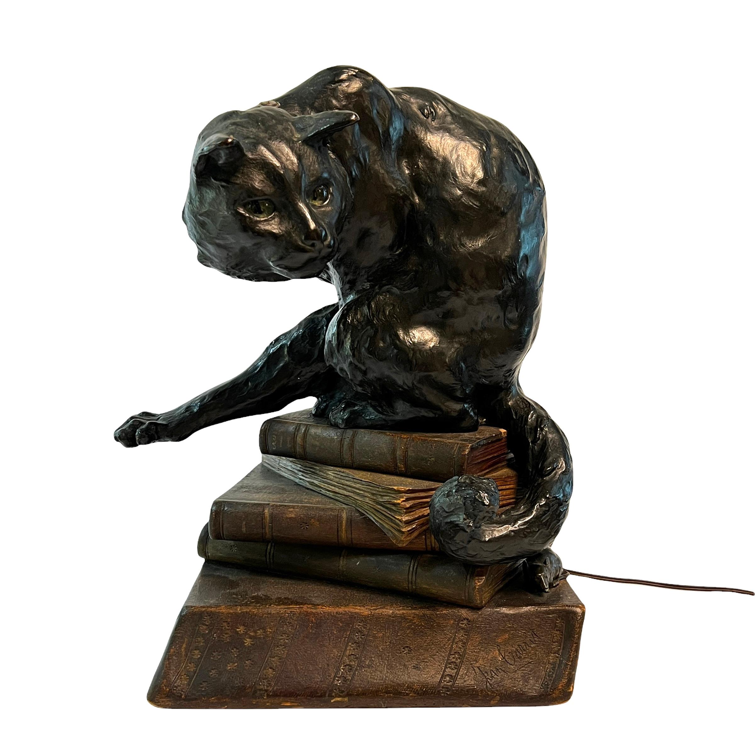 Our very rare lighted sculpture by the French artist, Jean Carrit, depicts a cat perched atop a stack of books with a mouse hiding beneath. Exquisitely sculpted and cast in bronze with dark brown patina, mounted on a base of stacked books carved