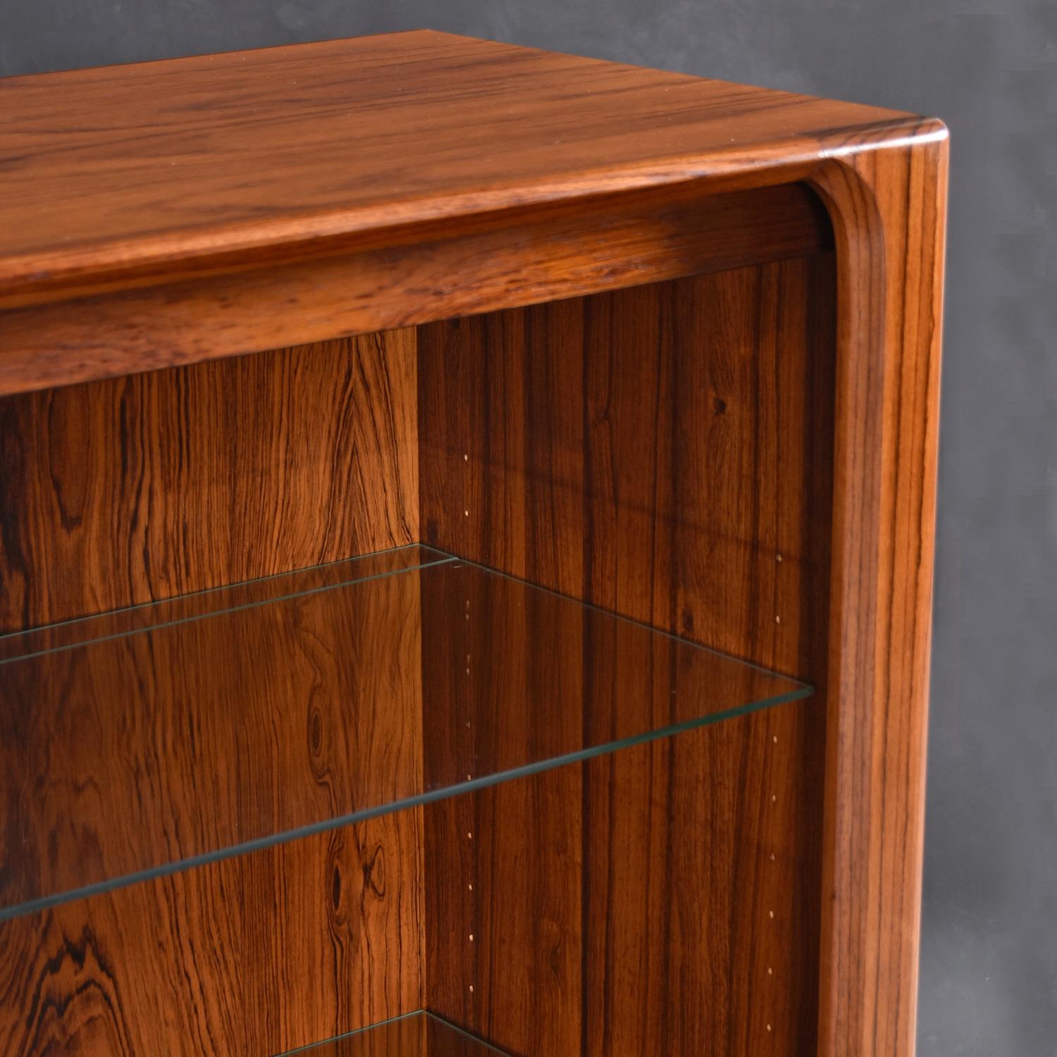 Librería iluminada danesa de palisandro con puerta de cristal y tiradores tallados en venta 2