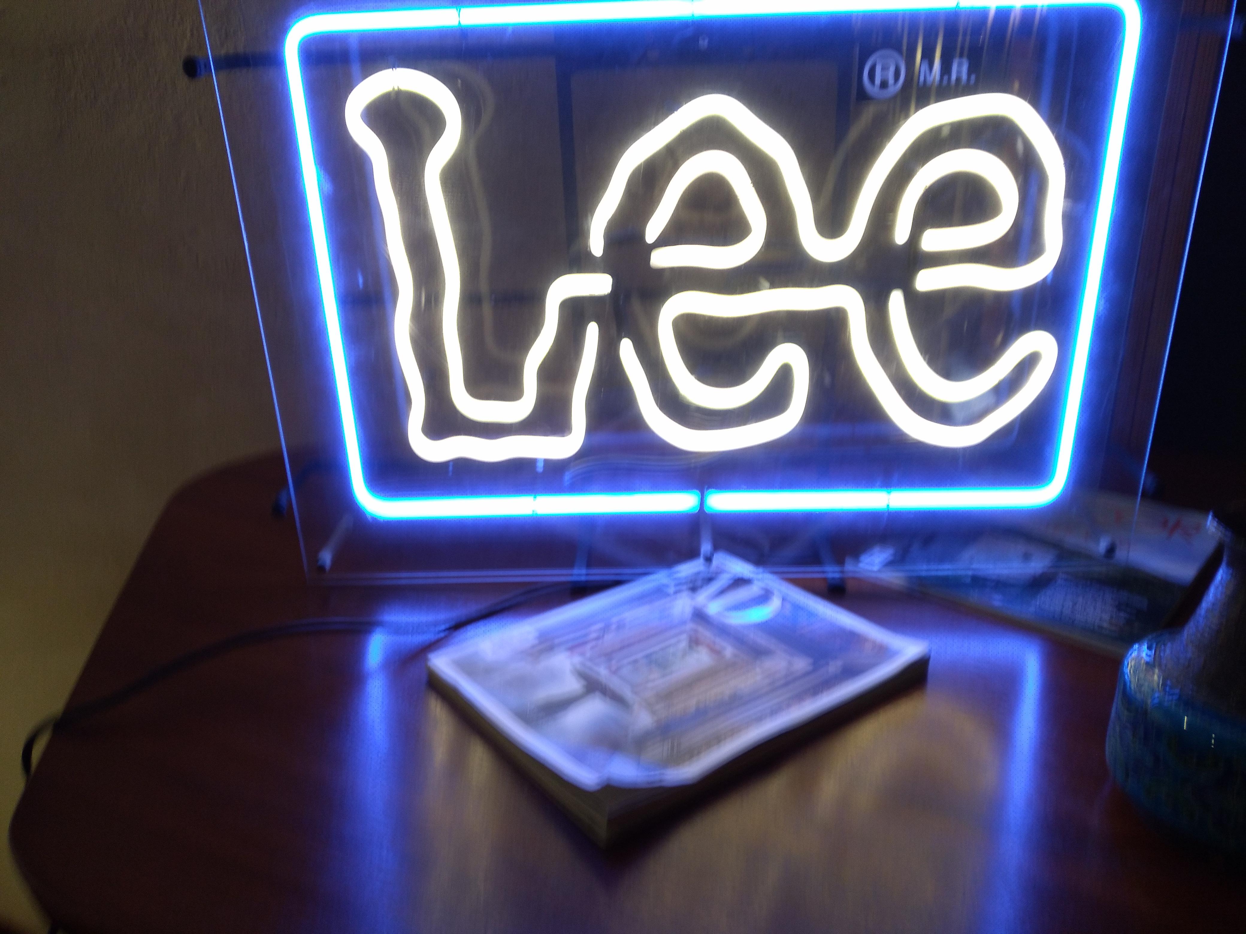 Lighted sign from Lee Jeans (after) Keith Harring. Artistic bright lettering. Plexiglas Plastic Neon. Decoration Light.