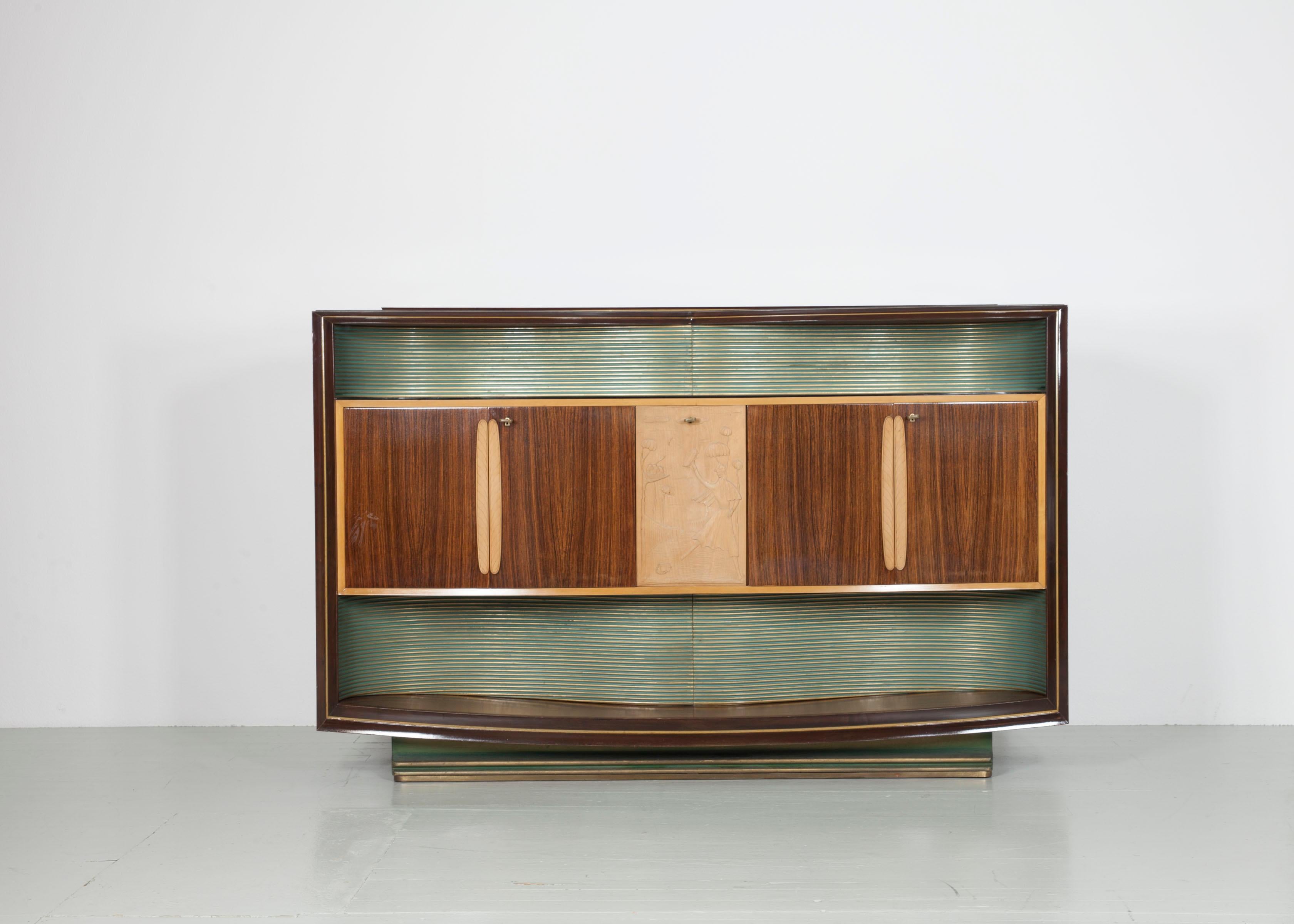 Lighted Midcentury drinks cabinet from the 1950s. Designed was the cabinet by Vittorio Dassi and manufactured by La Permanente Mobili Cantù. This massive cabinet is made of nut tree and maplewood. Behind the doors is a etched mirror with sun and