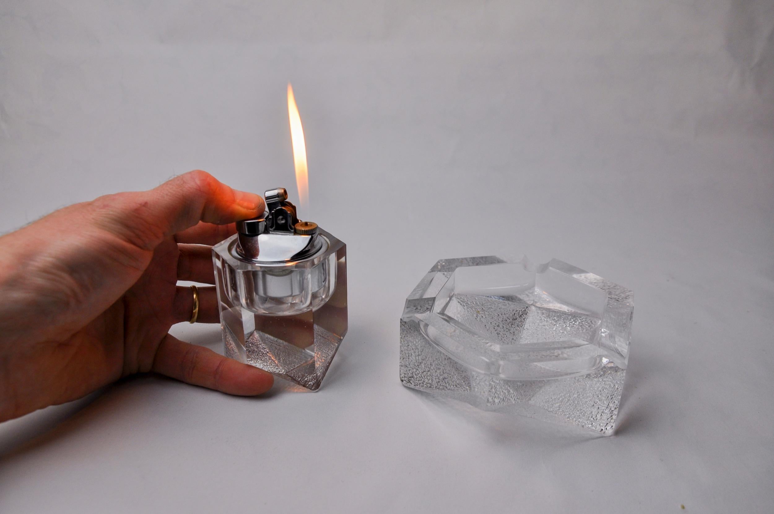 Splendido set composto da accendino e posacenere con effetto cubo di ghiaccio, disegnato e prodotto da Antonio Imperatore in Italia negli anni Settanta. Due oggetti unici in vetro di Murano smerigliato realizzati a mano da maestri vetrai veneziani.
