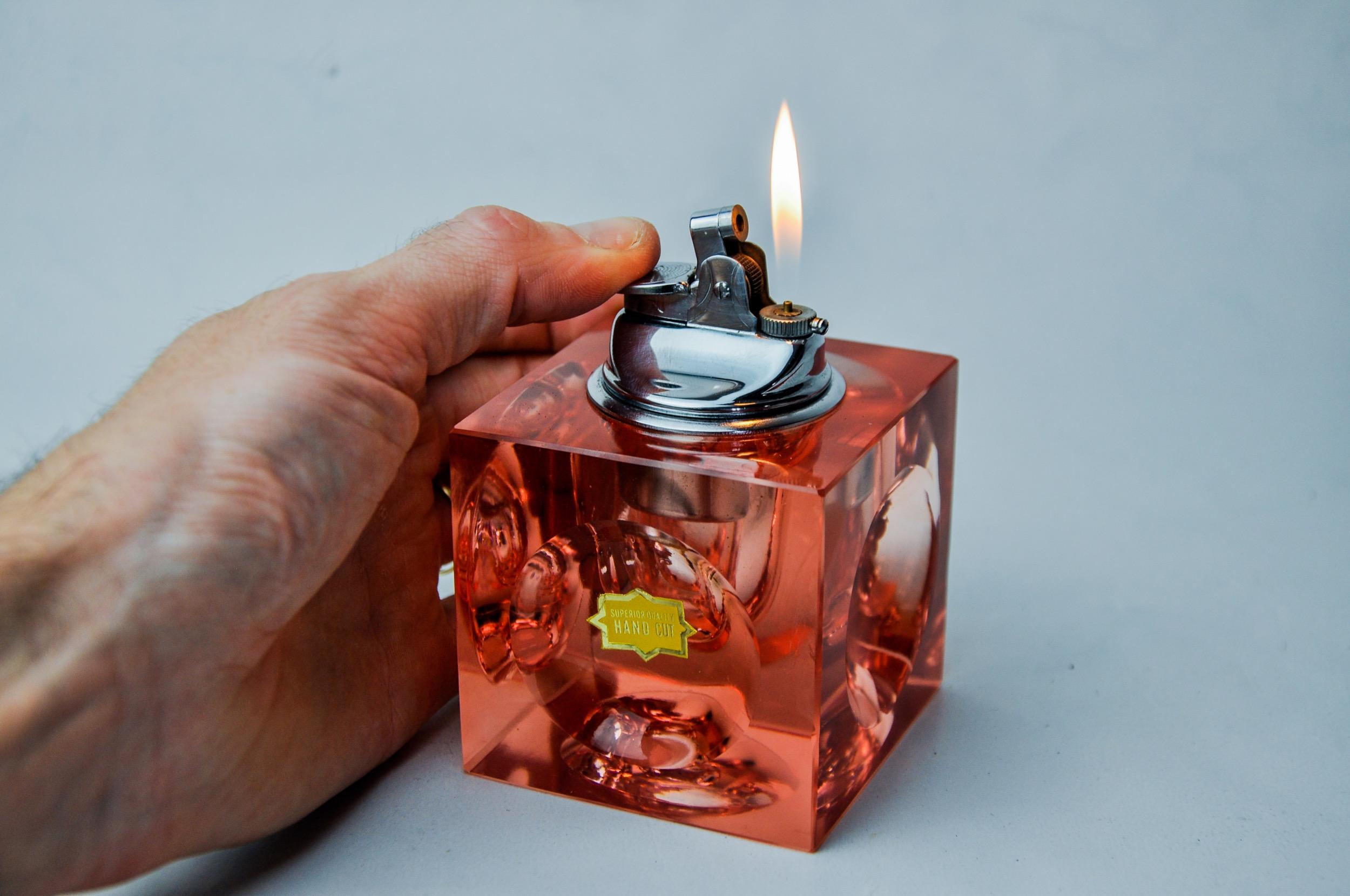 Superb magnifying lighter designed and produced by Antonio Imperatore in Italy in the 1970s. Pink murano glass lighter with a magnifying effect on its facets, handcrafted by Venetian master glassmakers. Decorative object that will bring a real