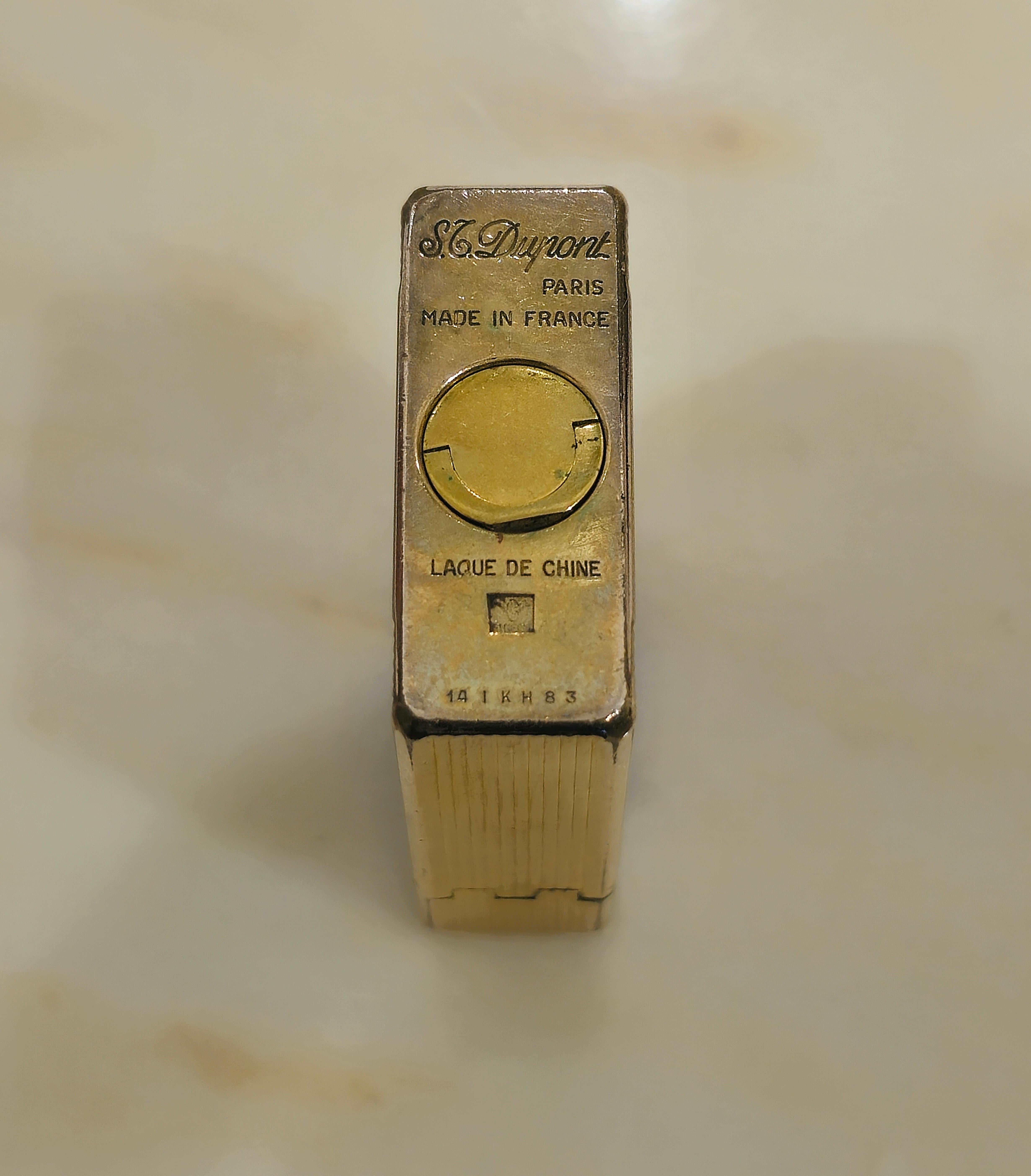 Leichtere S.T. Dupont Porzellanlack braun ist ein LUXUS-Produkt, das für seine Eleganz und hervorragende Qualität bekannt ist. Dieses spezielle Modell mit seiner Lackierung und 18-Karat-Vergoldung ist besonders begehrt. Mit klaren Linien und