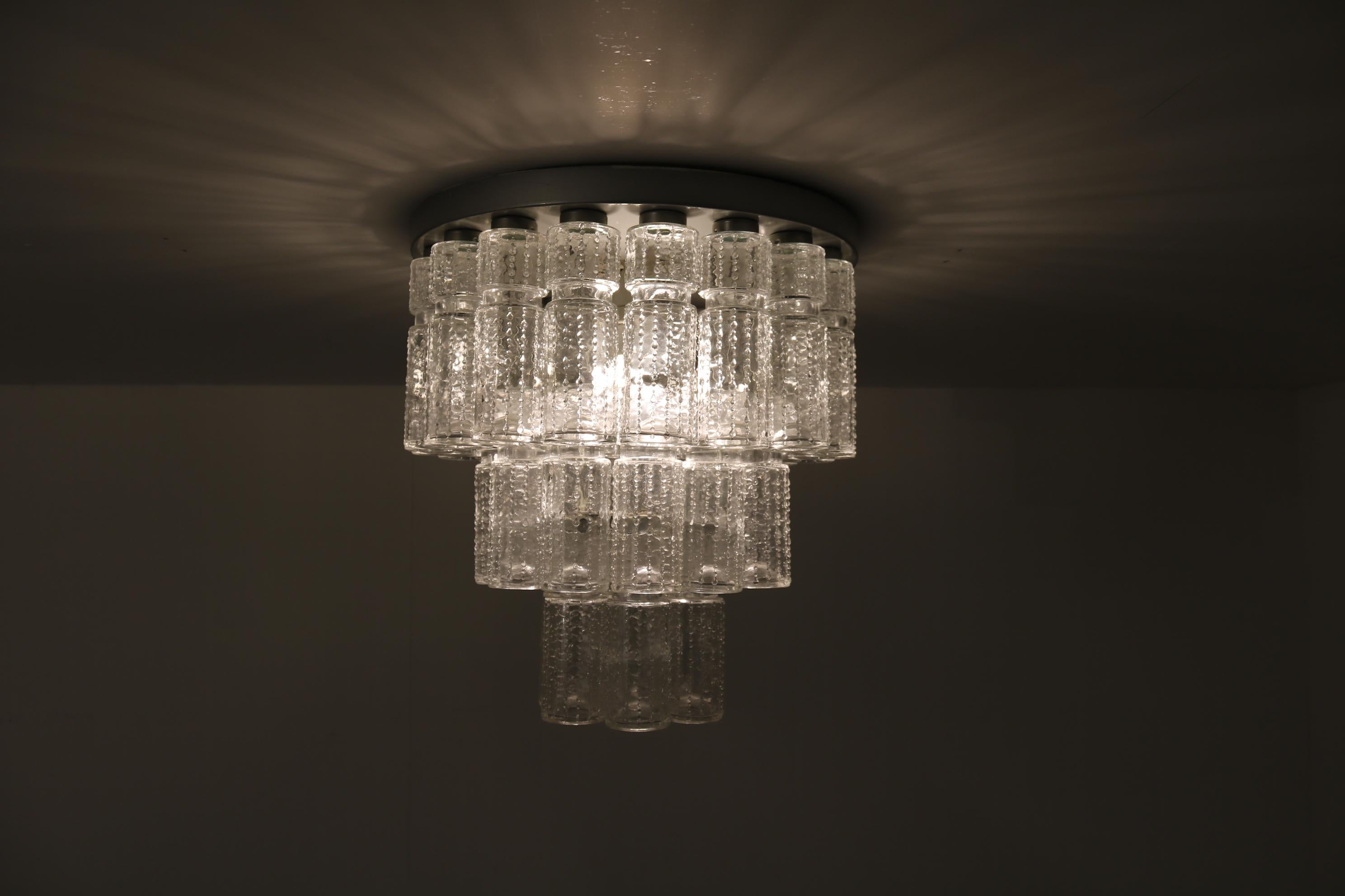 A very elegant ceiling lamp, manufactured by RAAK in the Netherlands circa 1960.

This eye-catching piece has a round aluminium base on which many clear glass cylinders hanging down in different heights. This gives the piece an icicle-like style