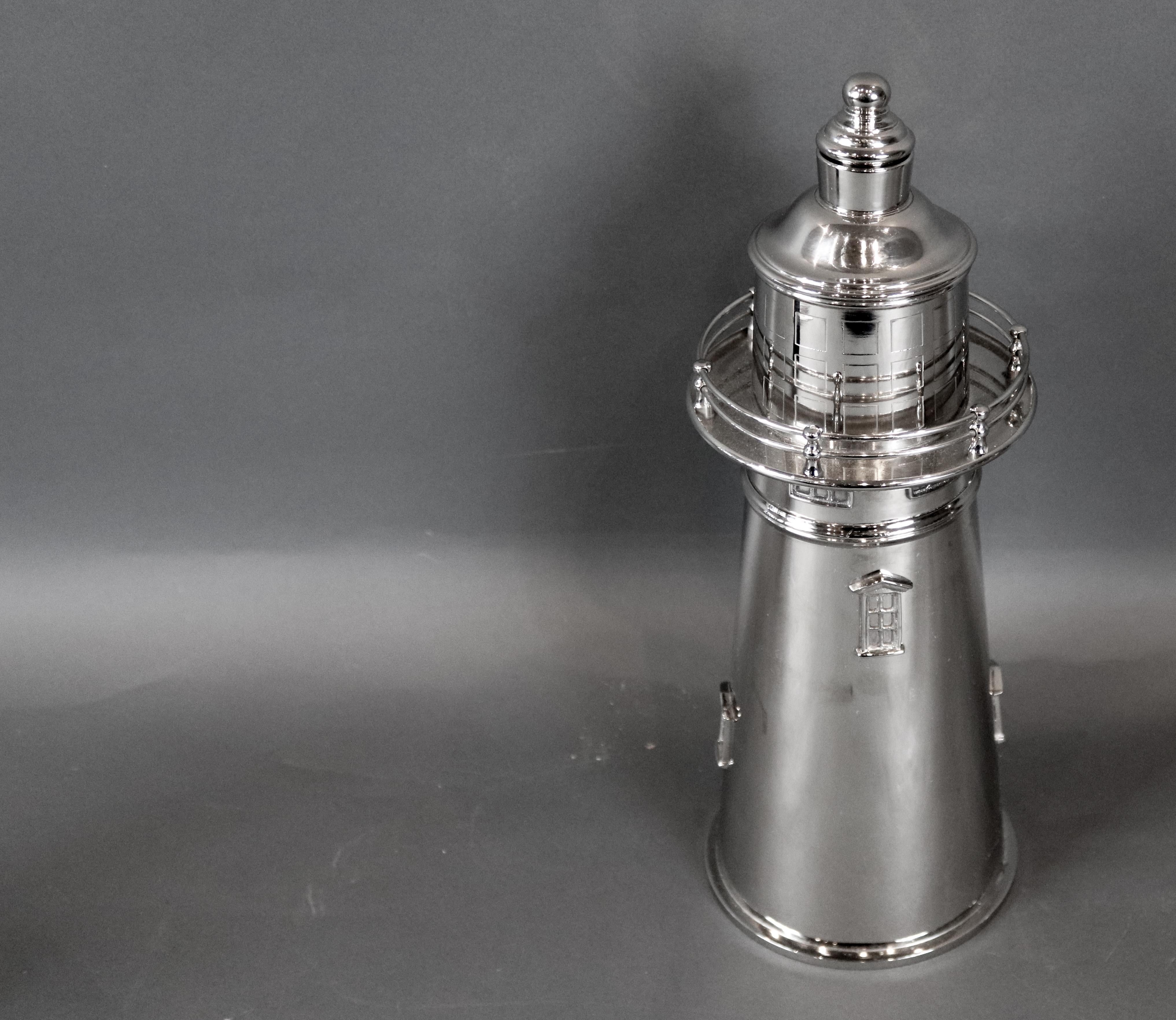 Chrome-plated cocktail shaker with removable top and strainer. With details including railing windows. Measures: 14