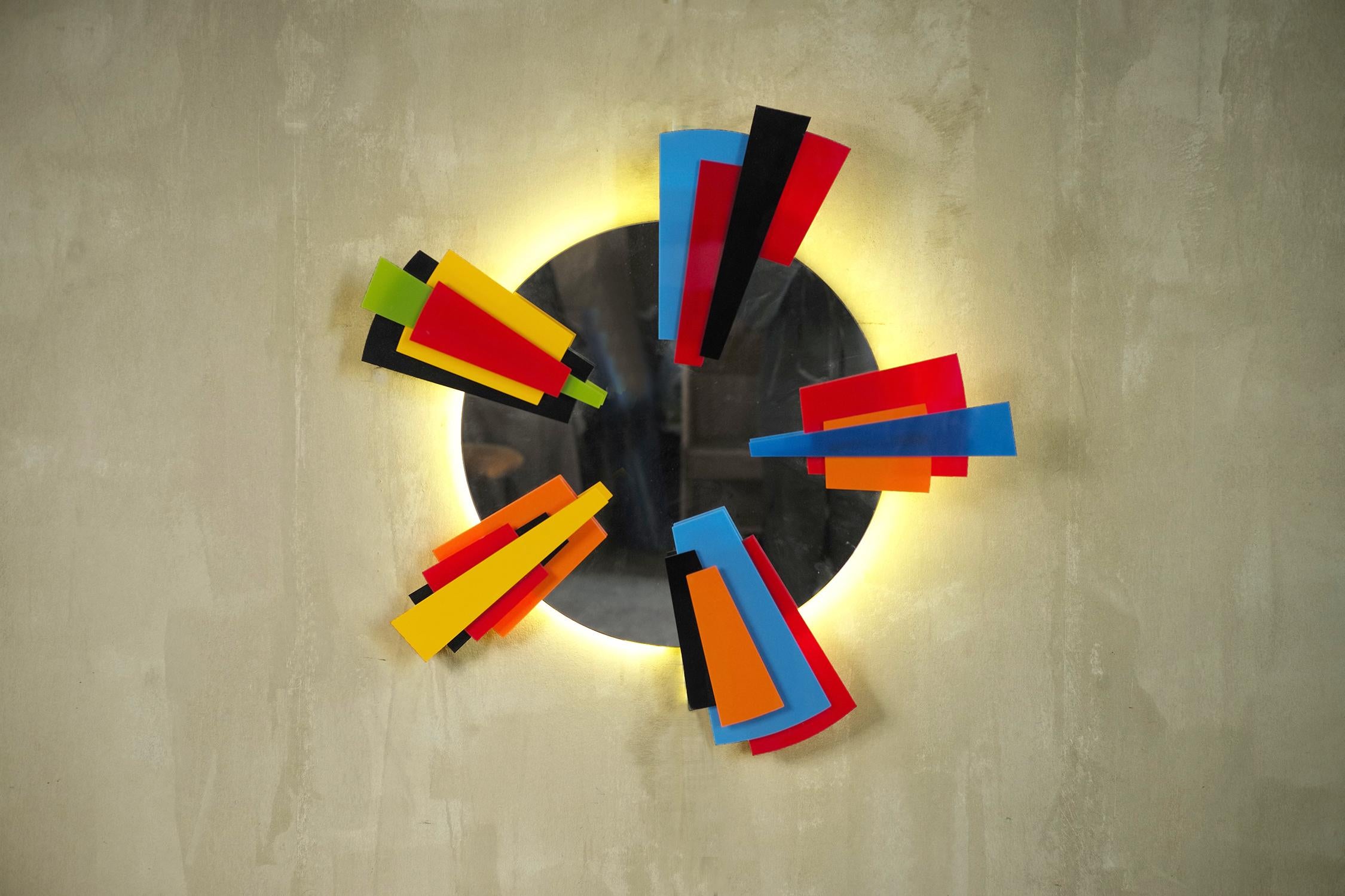 Backlit circular mirror, France 2000. Pieces of colored plexiglass are superimposed and arranged in a star. A white LED lighting system is installed at the rear. This creation is part of a small series created by a visual artist in the 2000s, each
